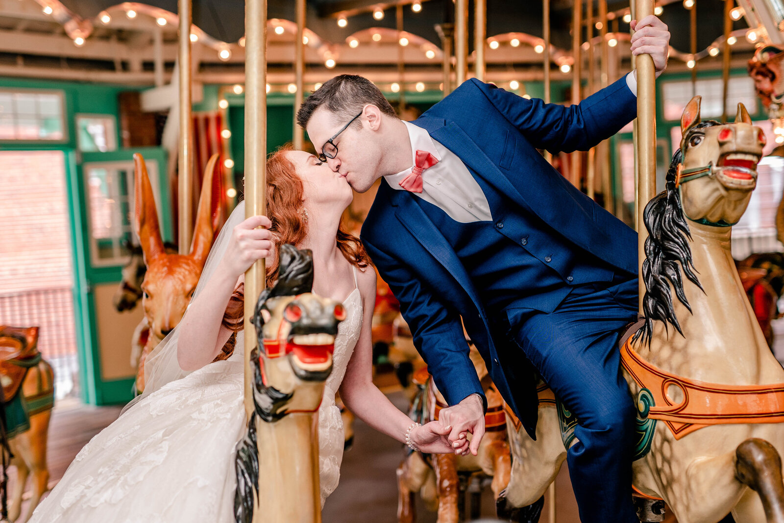 A bride and groom share a kiss on the carousel during their wedding at Glen Echo Park in Washington DC