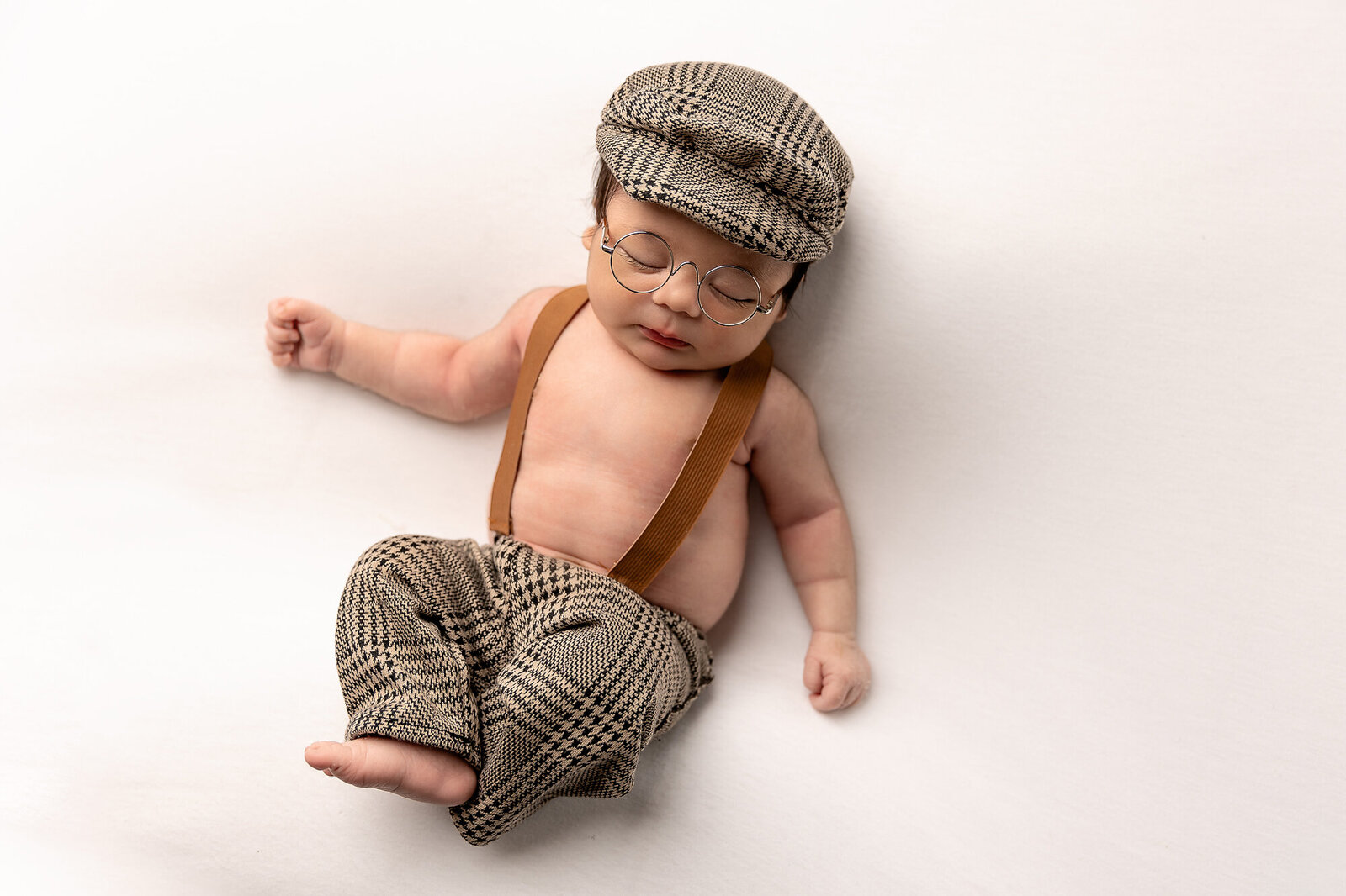 baby in suspenders and hat by Newborn Photography Bucks County PA