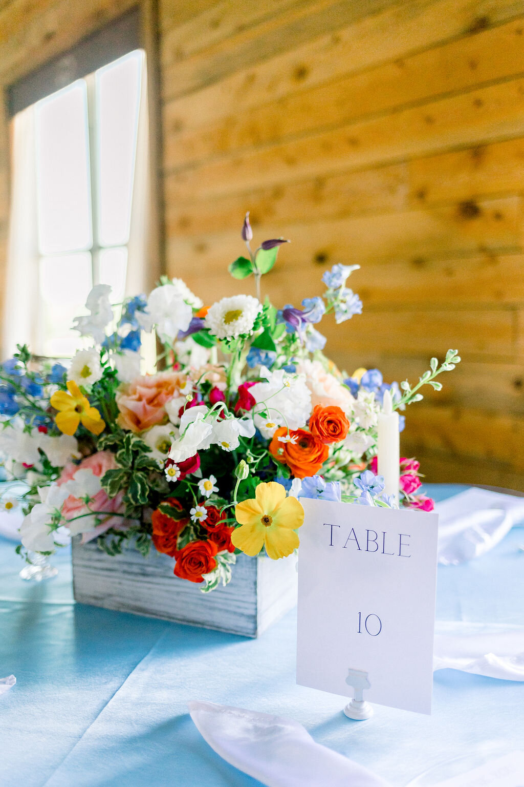 spring florals in white wooden box on blue tablecloth