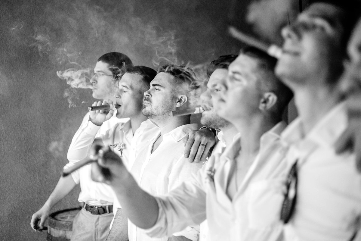 Groom and groomsmen smoke cigars at Brookmere Winery in Belleville, PA by the Jepsons.