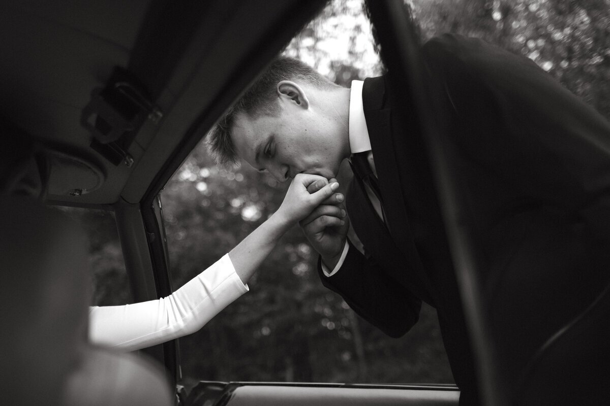 Groom kissing bride hand taken by washington adventure elopement photographer Erica Rochelle Photography