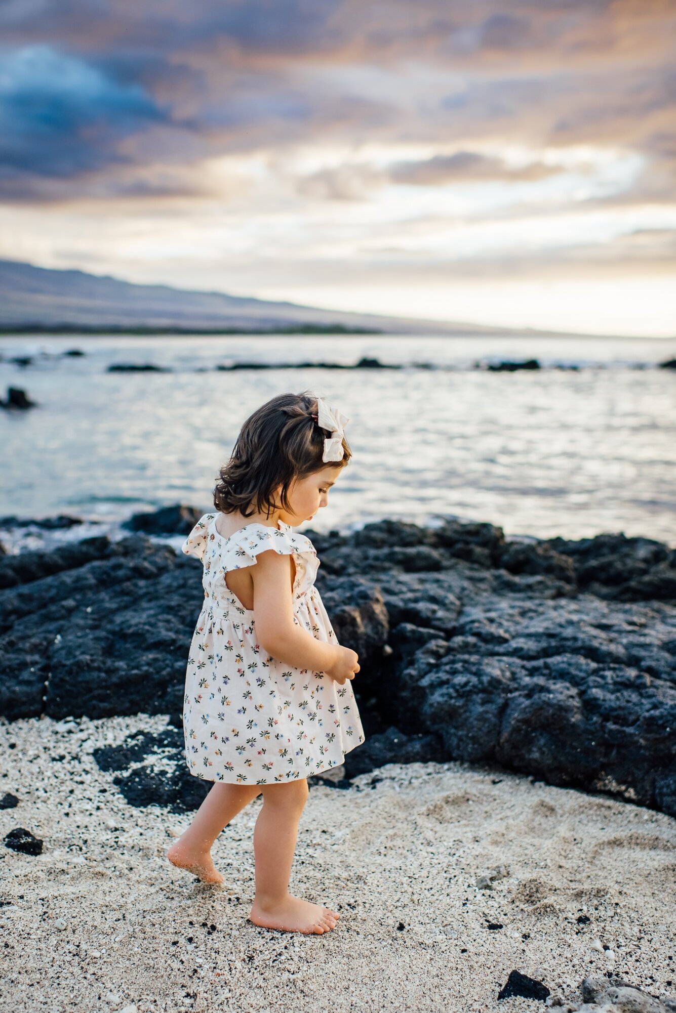 little girl walking on the beach at sunset