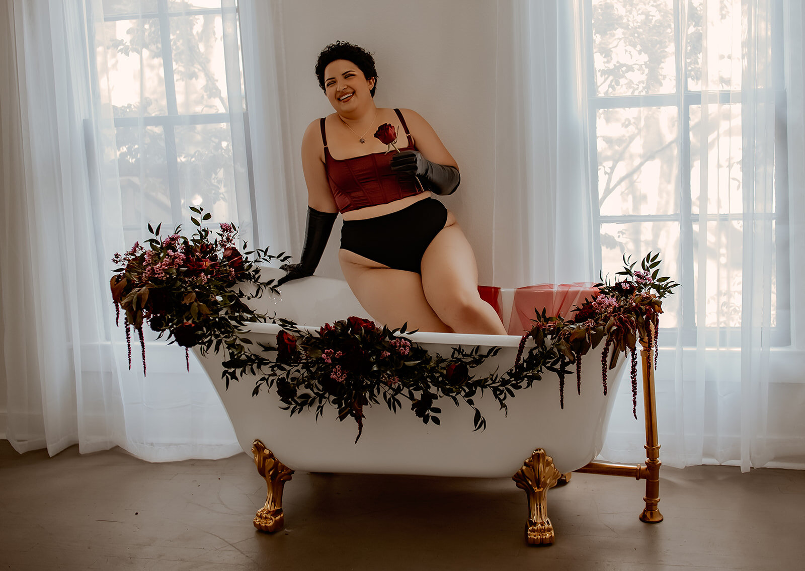 Boudoir photography session in Cleveland TX - empowering portraits in floral bathtub setup with confident smile