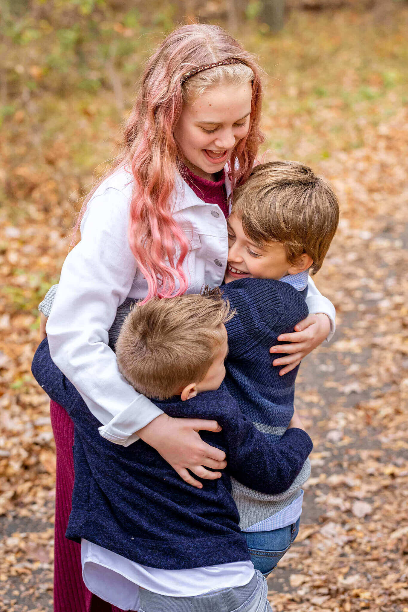 Three siblings hugging each other.