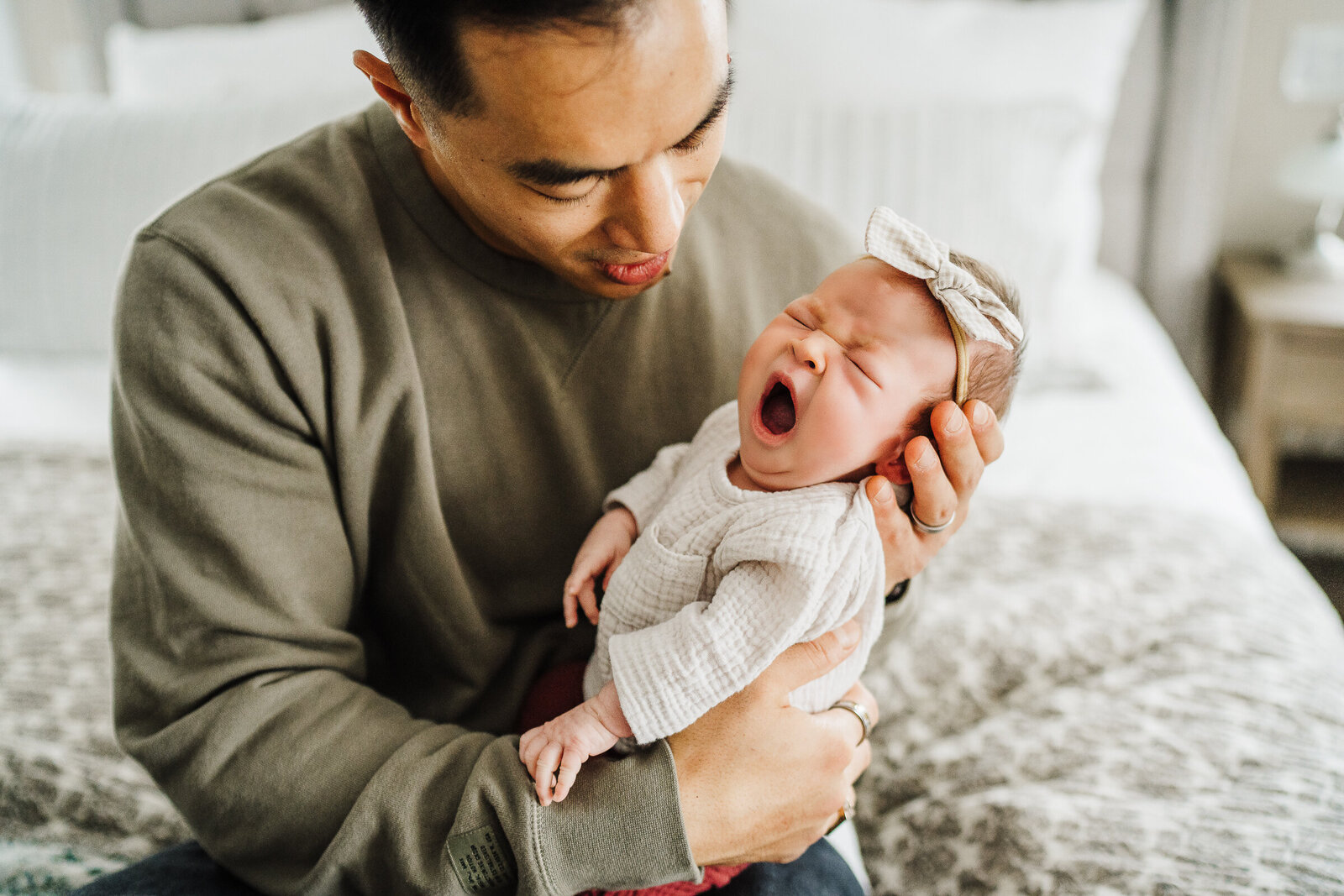 newborn yawns in dads arms in boston