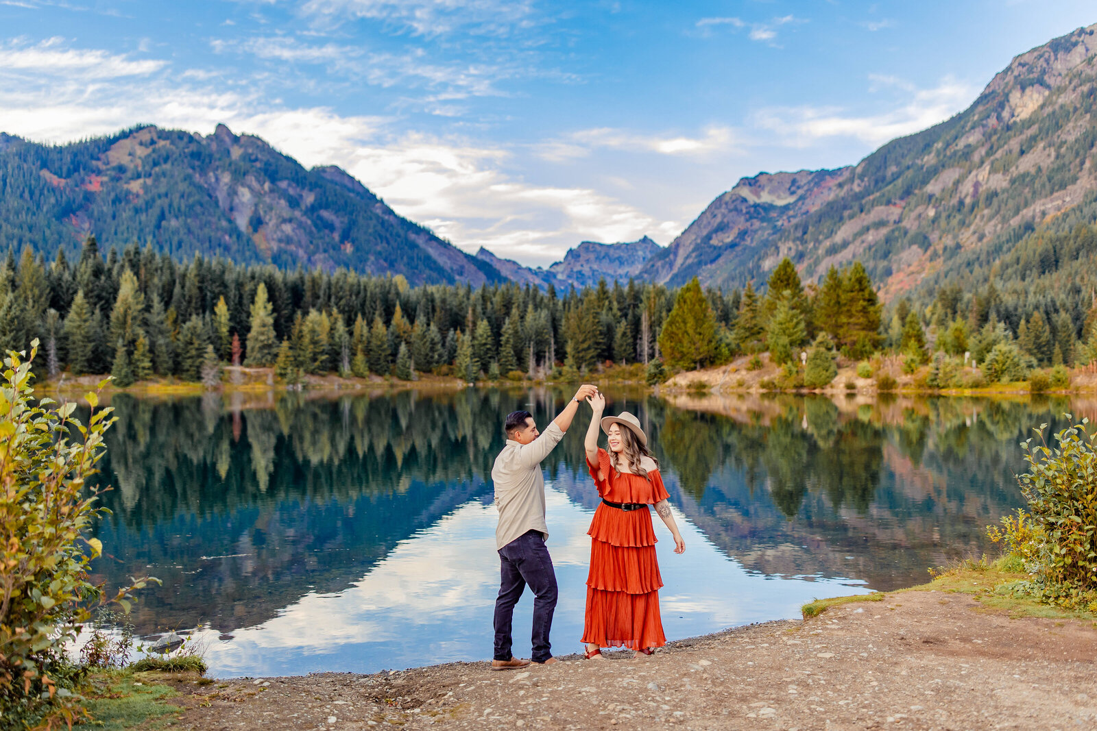 couple dancing in front of mountains and lake