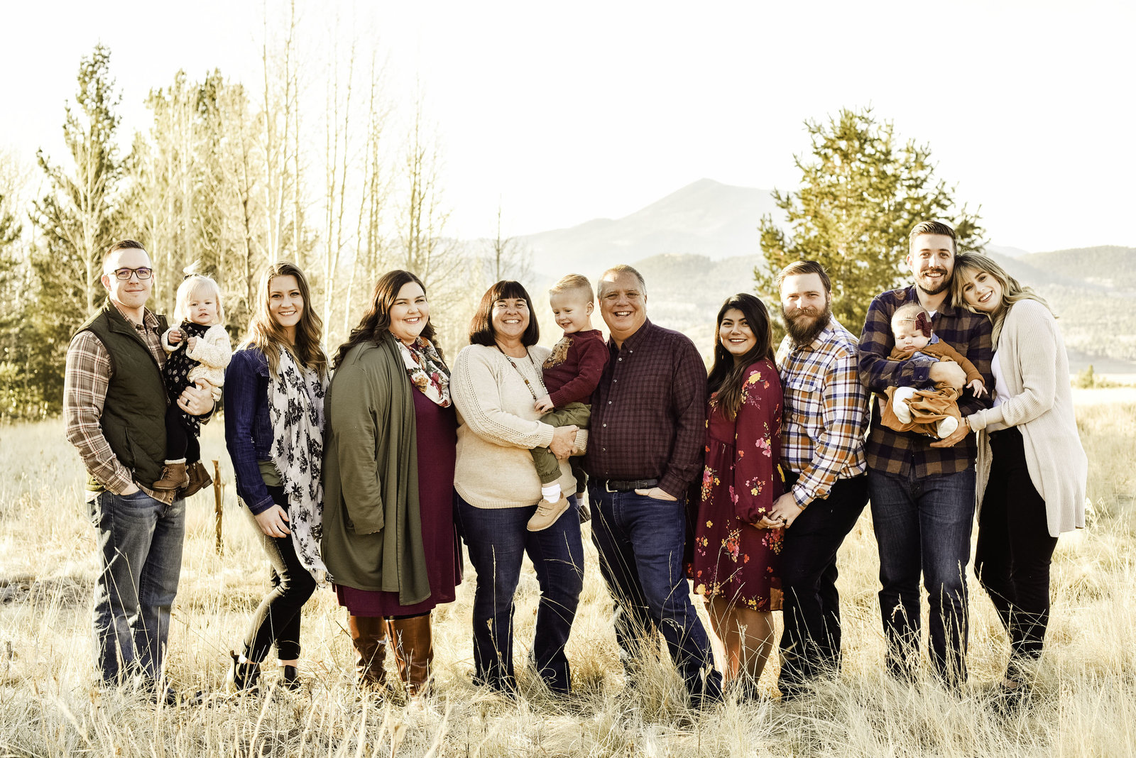 Flagstaff family at Snowbowl Lodge with aspens and mountains in background looking at camera
