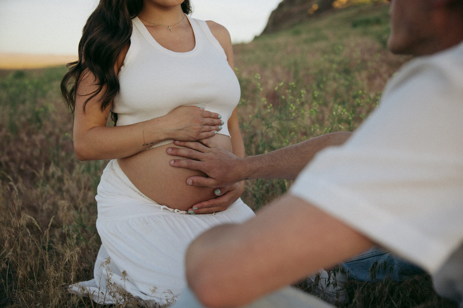 Close embrace of expecting couple in the forested Idaho mountains