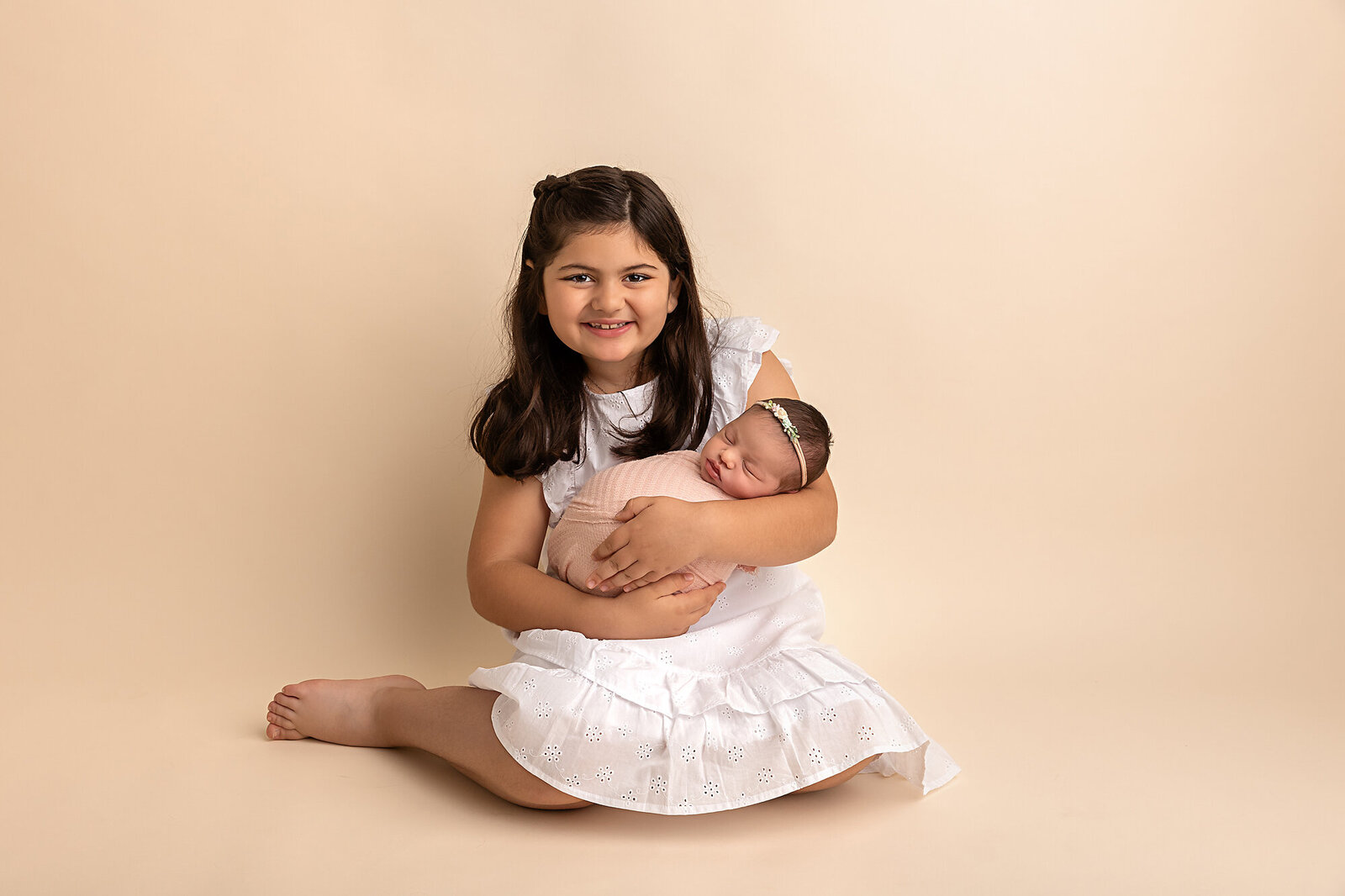 big sister holding baby sister