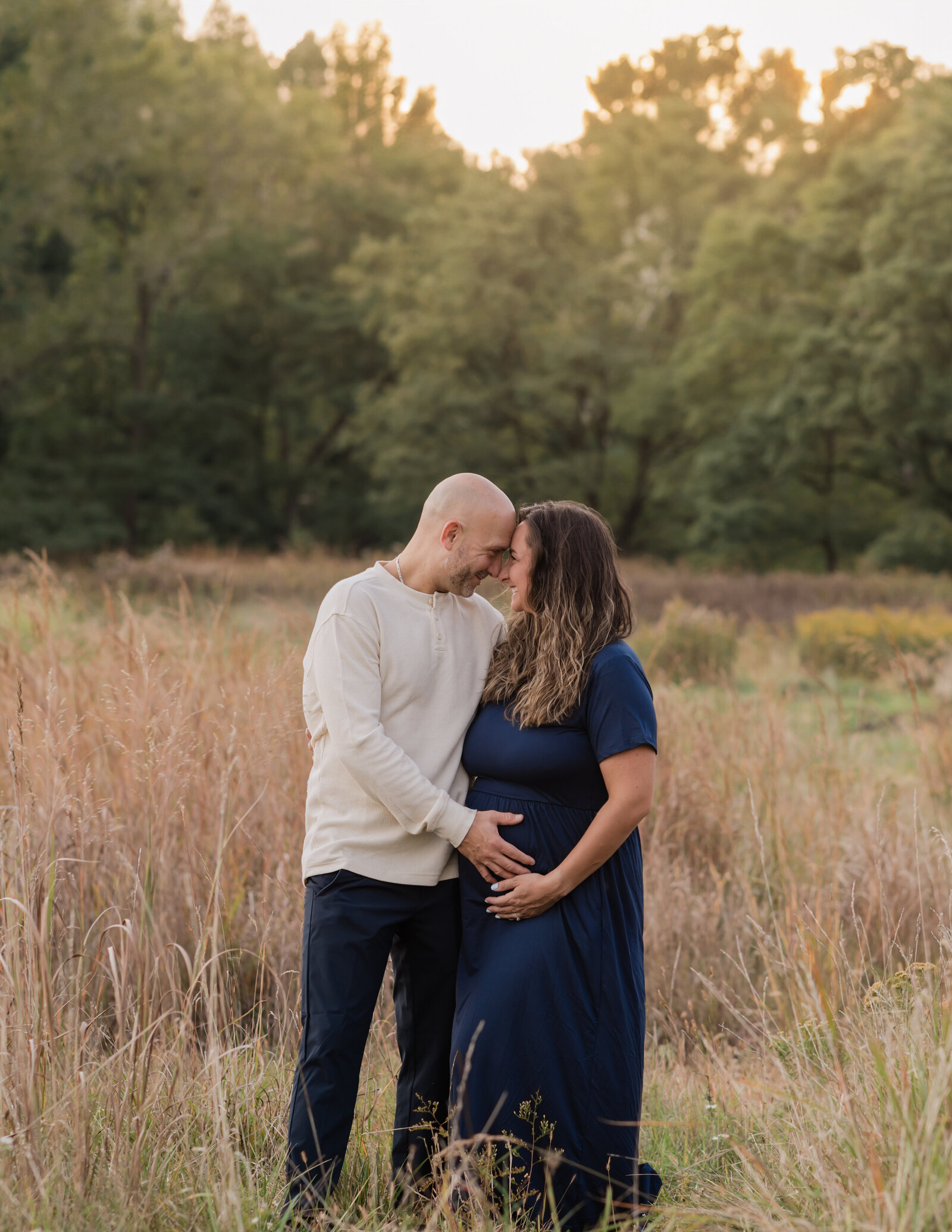 husband and pregnant wife holding belly for maternity photoshoot