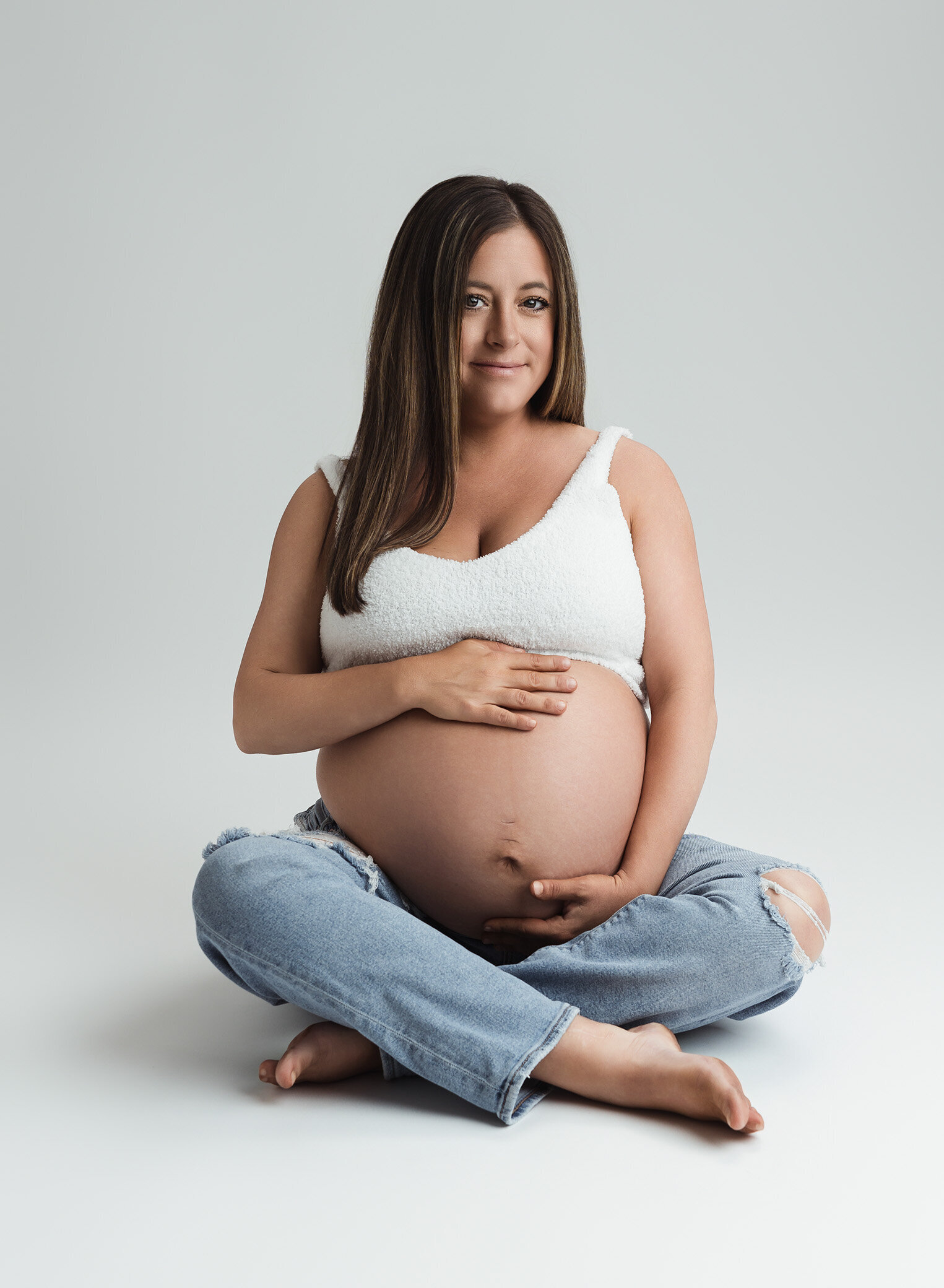 casual maternity photo in studio mom wearing jeans