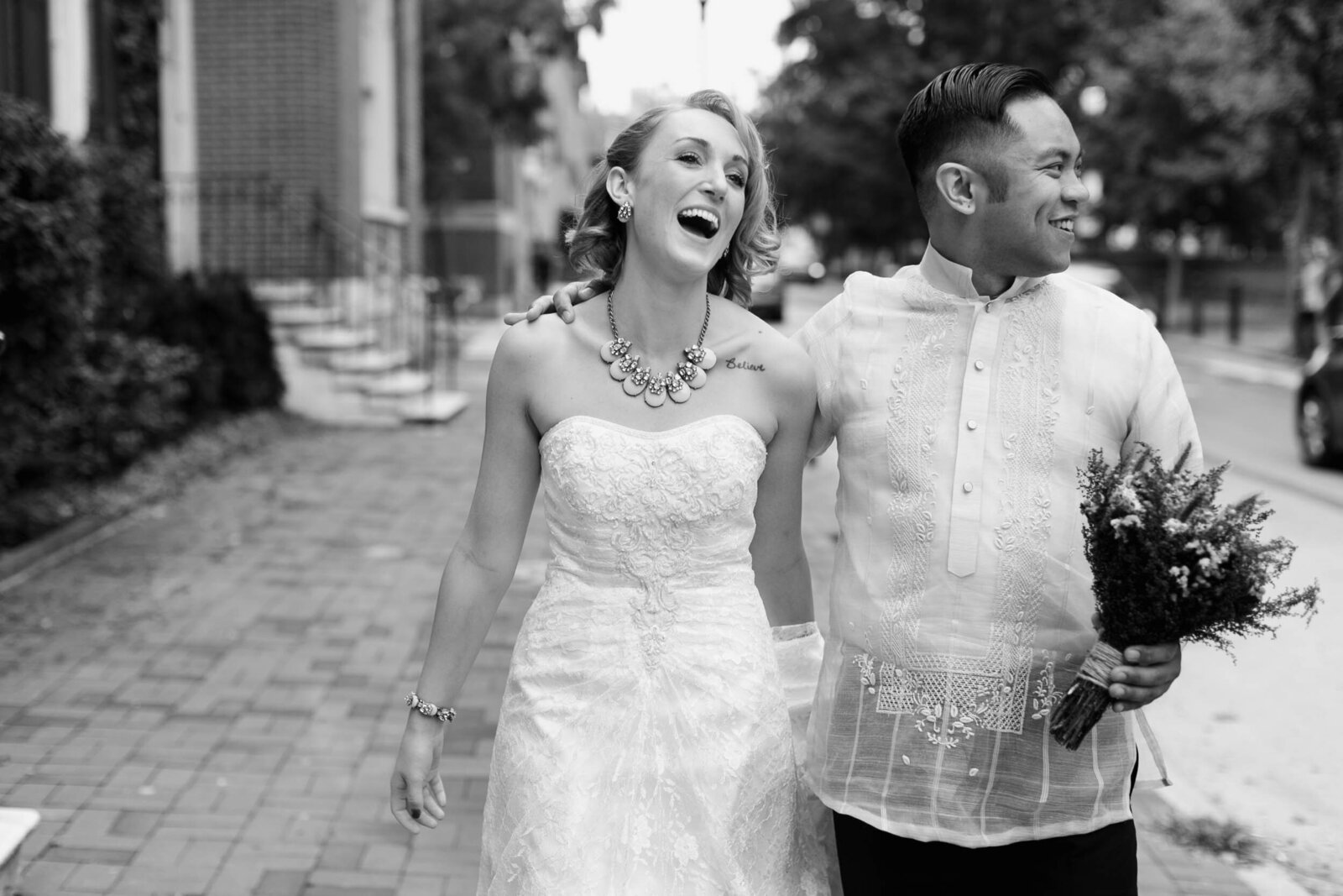 candid bride and groom walking city street