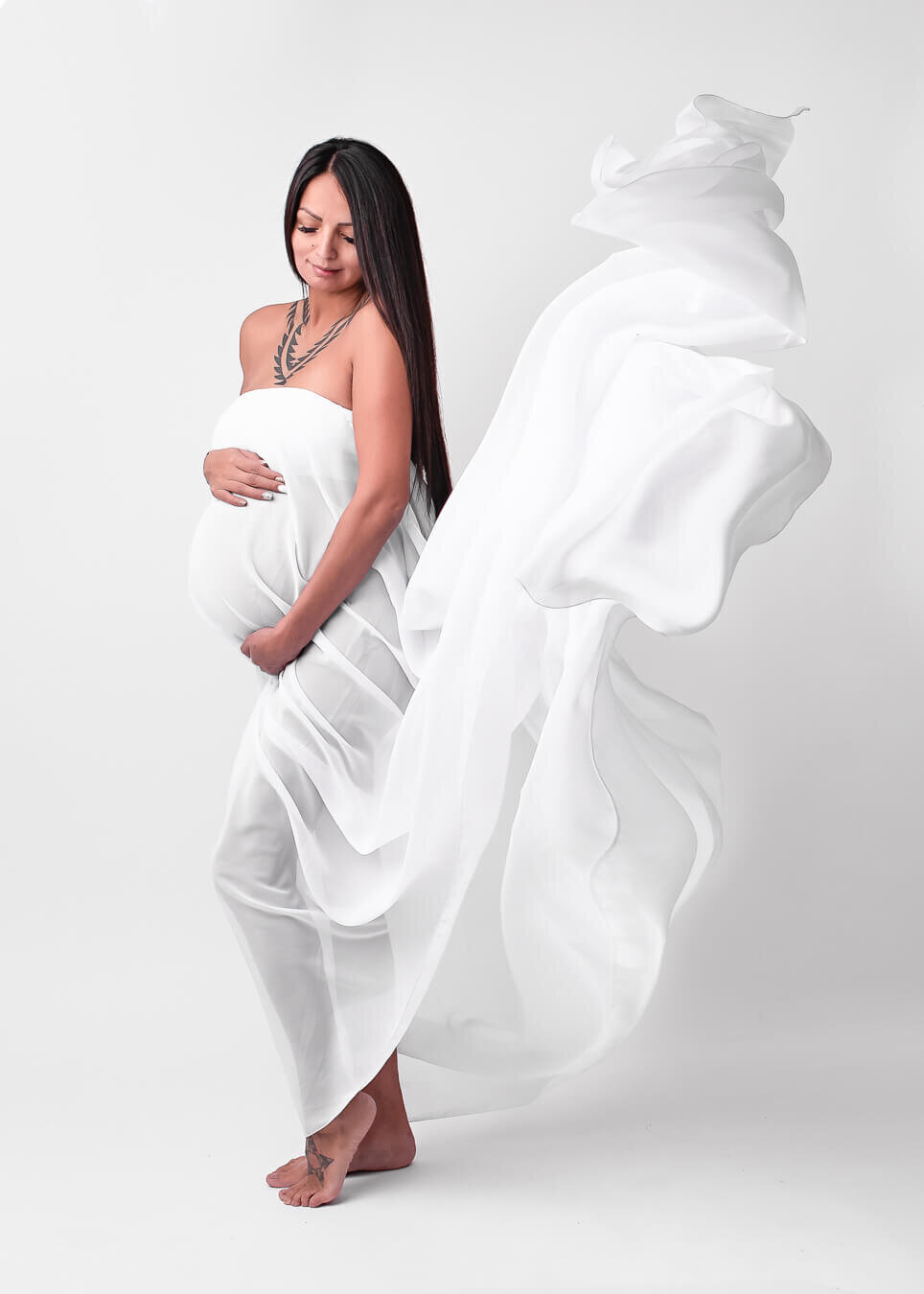 beautiful maternity portrait of woman draped with flowing fabric