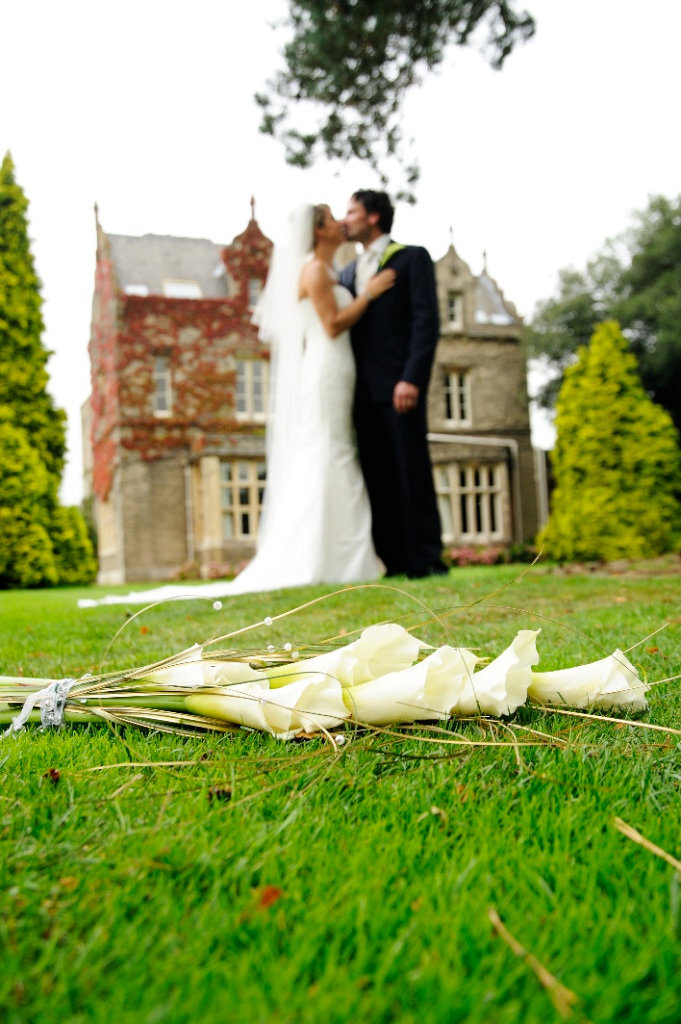 Bride and groom Kissing under tree tulips on the ground