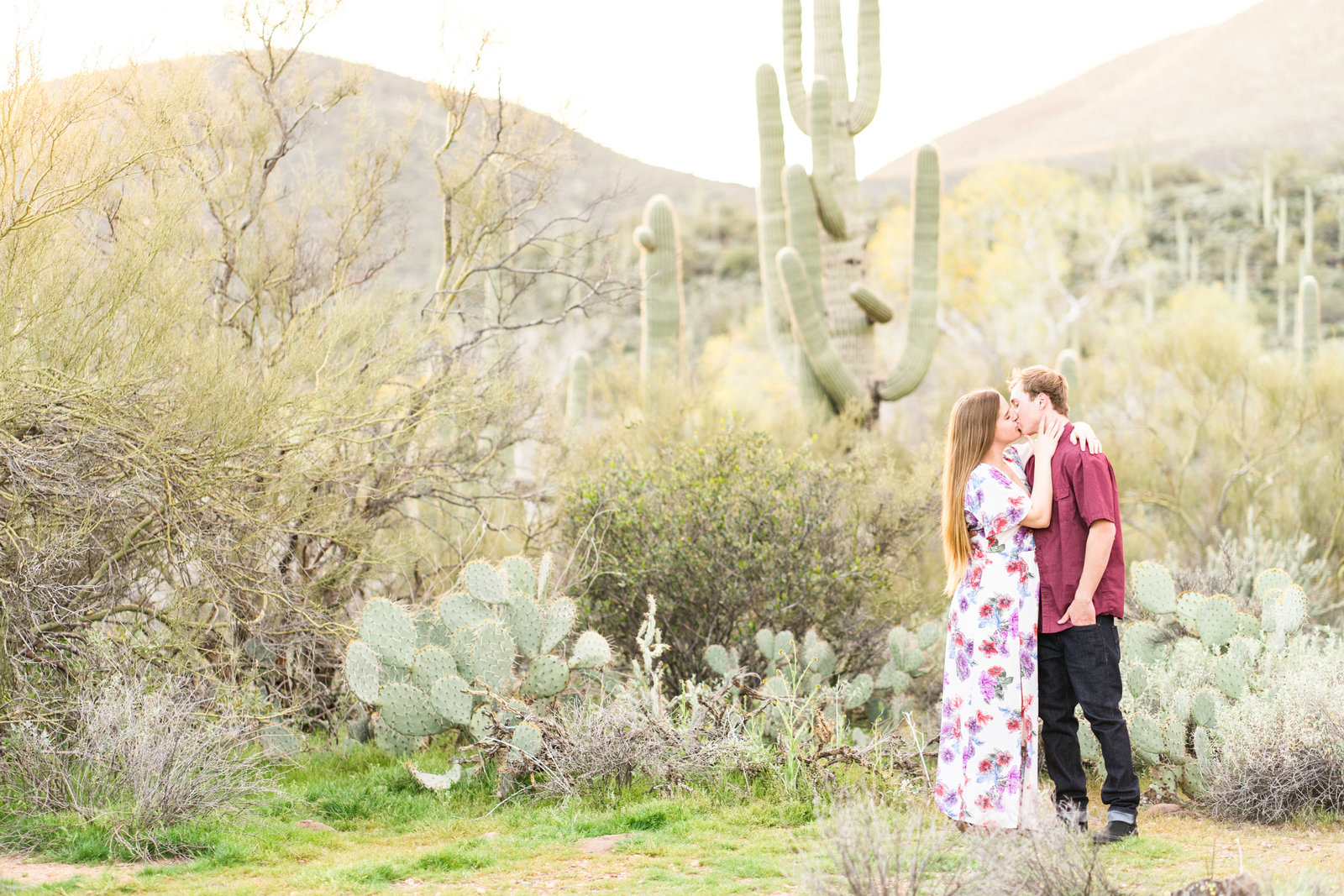 Couple kissing in front of mountains in desert