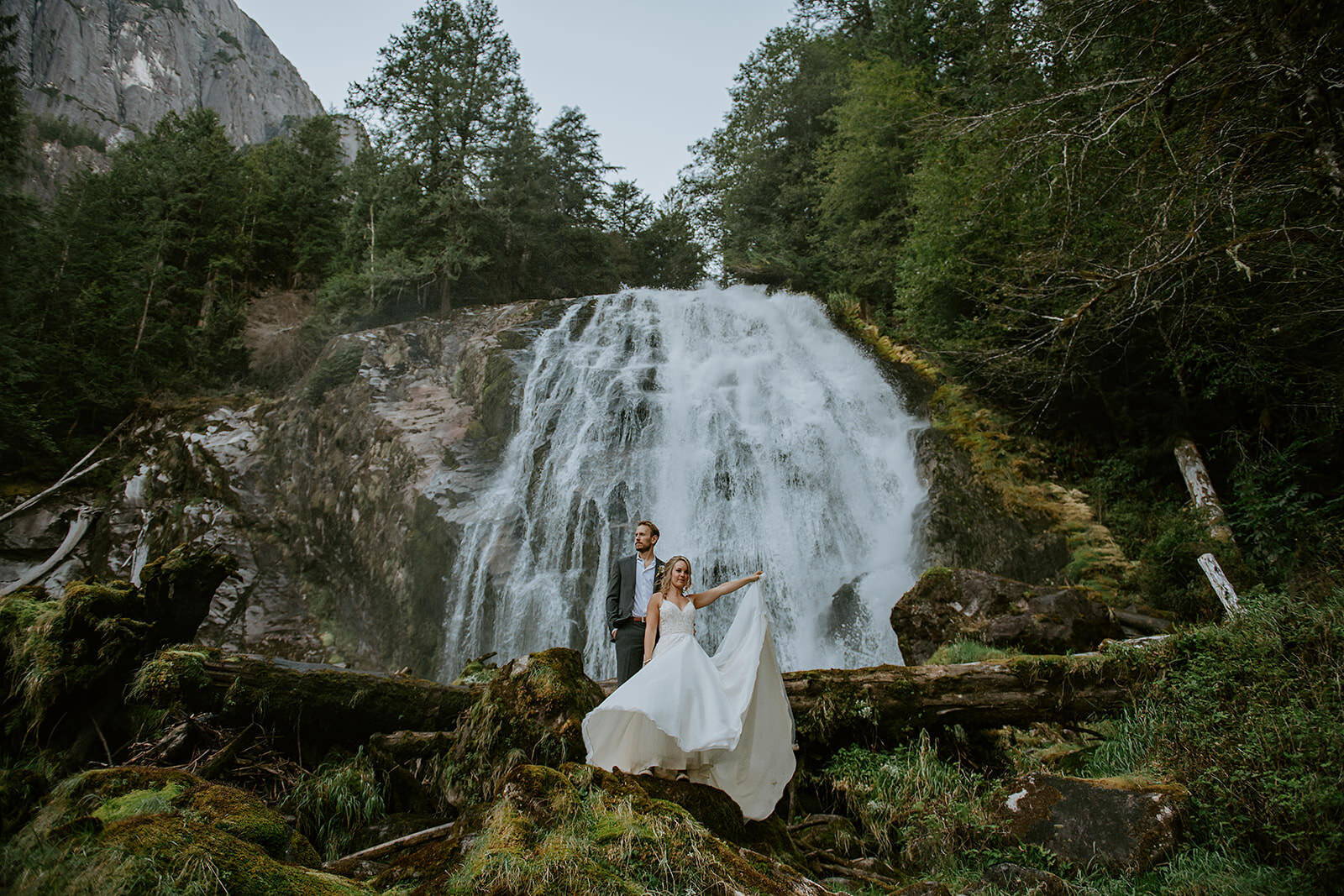 Couple standing under Chatterbox falls during their adventurous elopement.