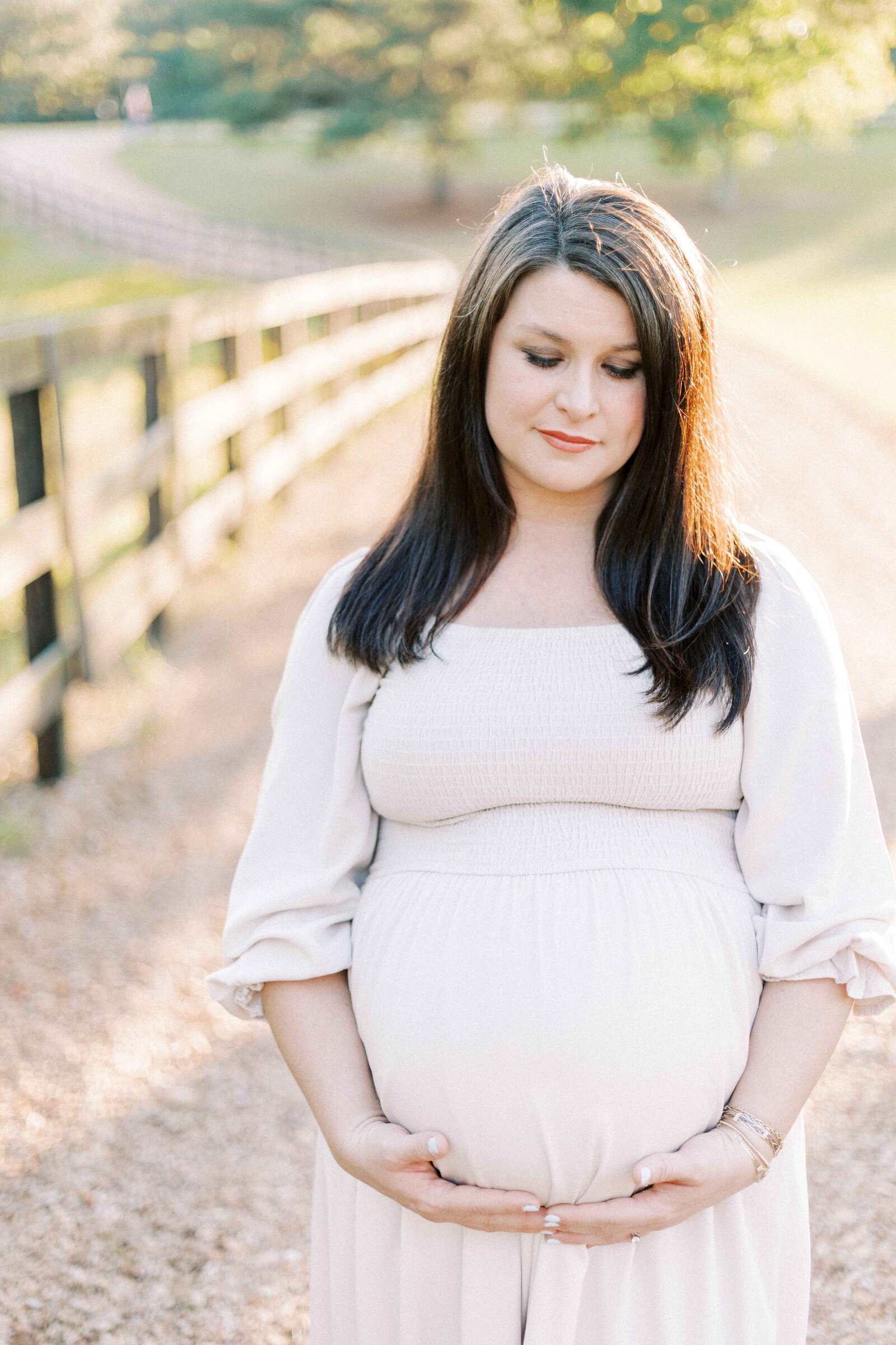 mom holding belly during maternity photos in peoria illinois 