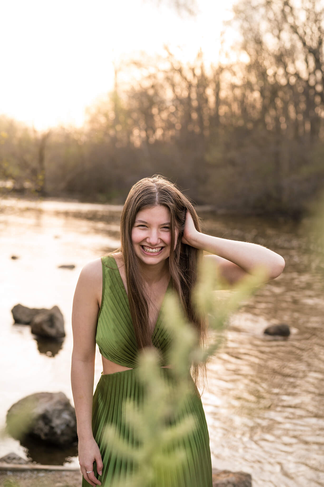 wearing beautiful green dress standing in front of a beautiful creek and laughing in Kensington Metropark.