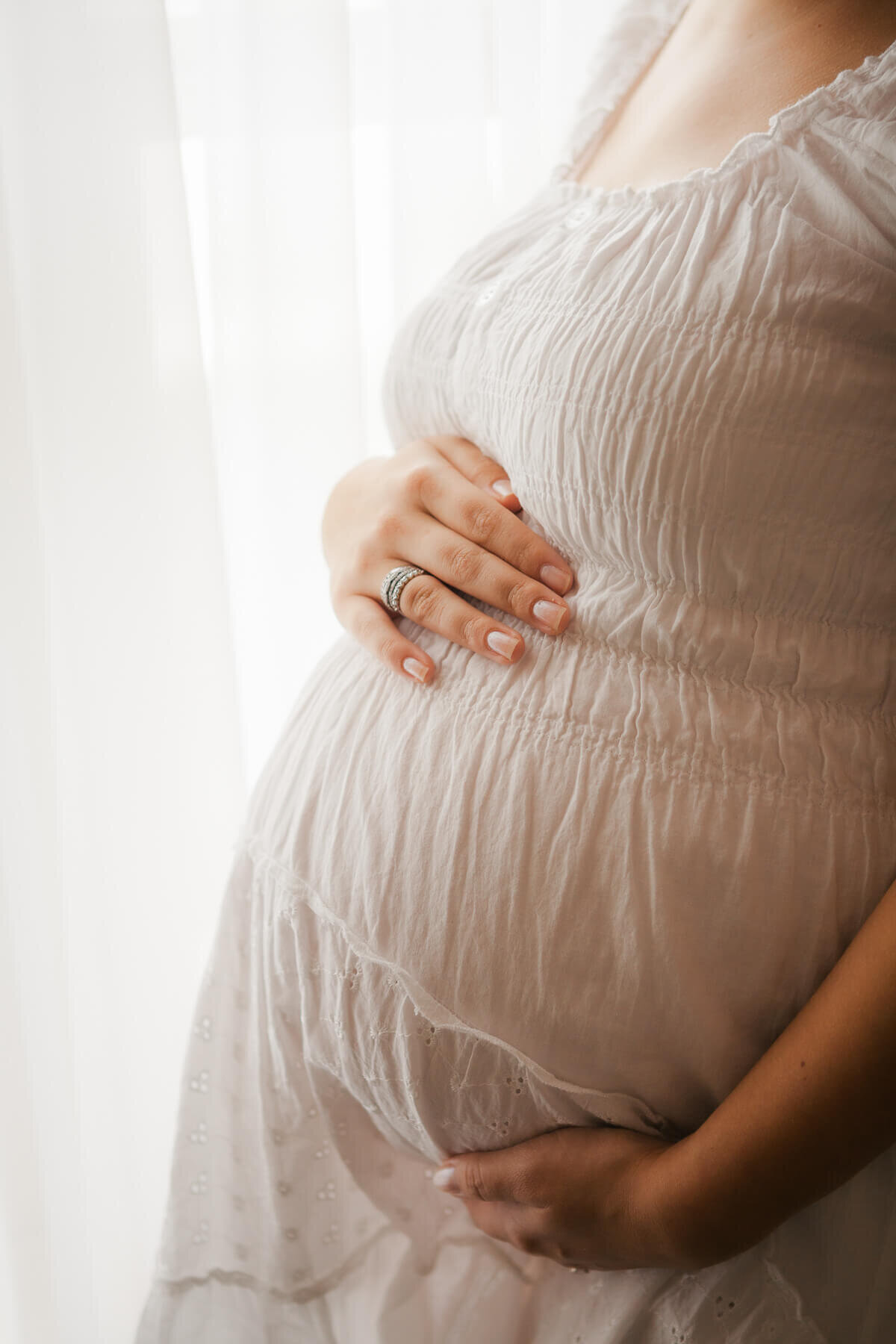 Cropped image of a baby bump and mamas arm under it