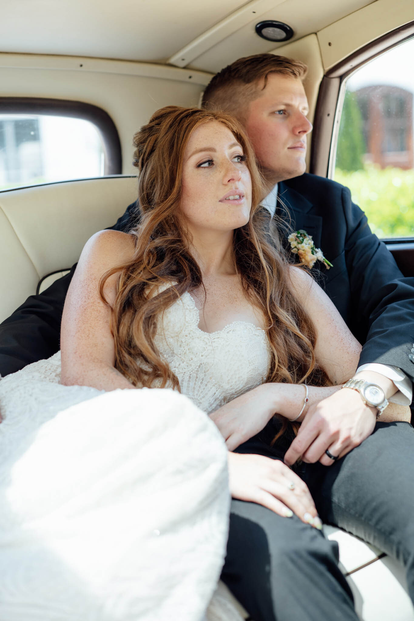 Bride and groom inside of their wedding car