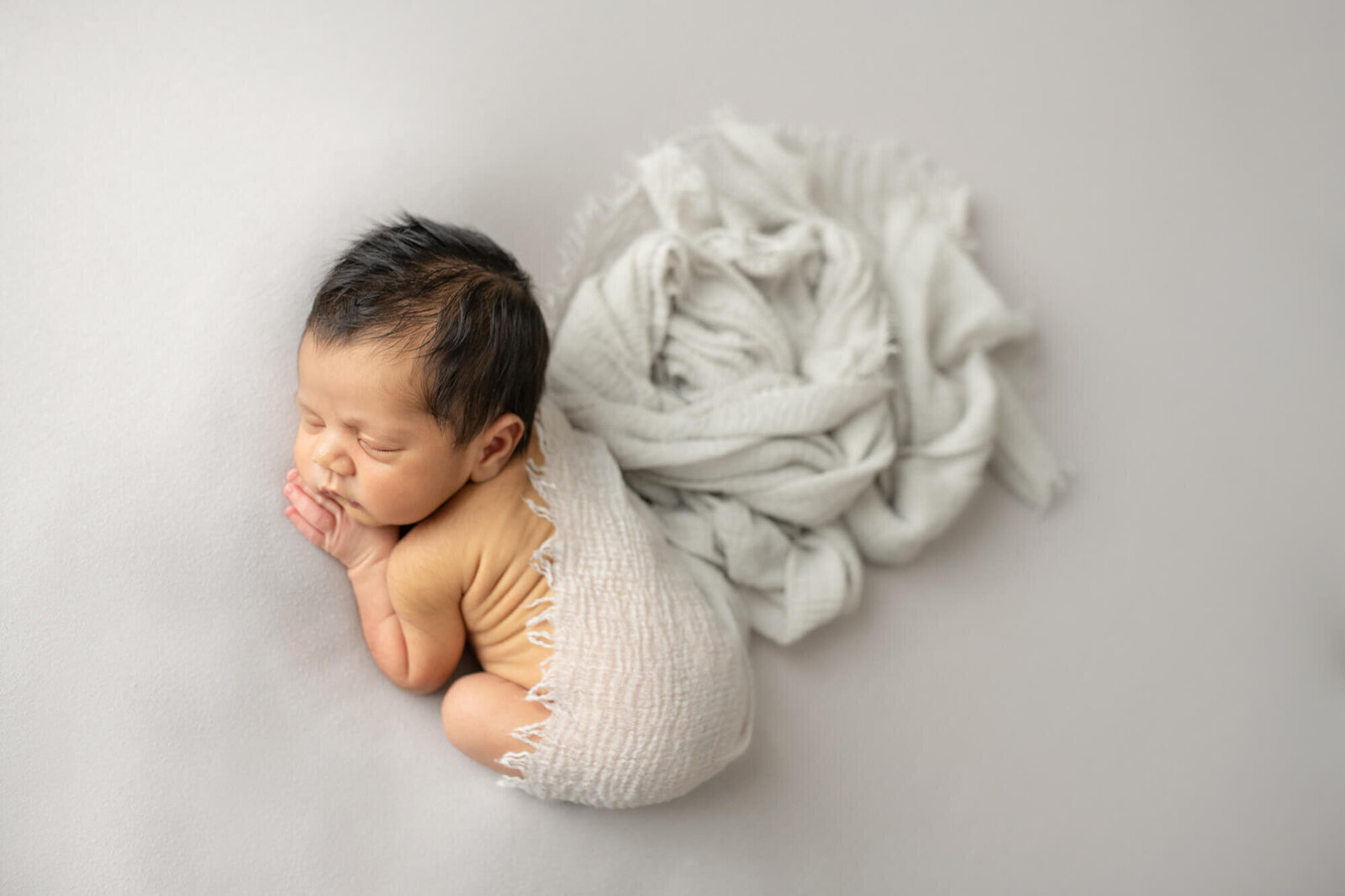 Newborn sleeping boy with neutral wrap