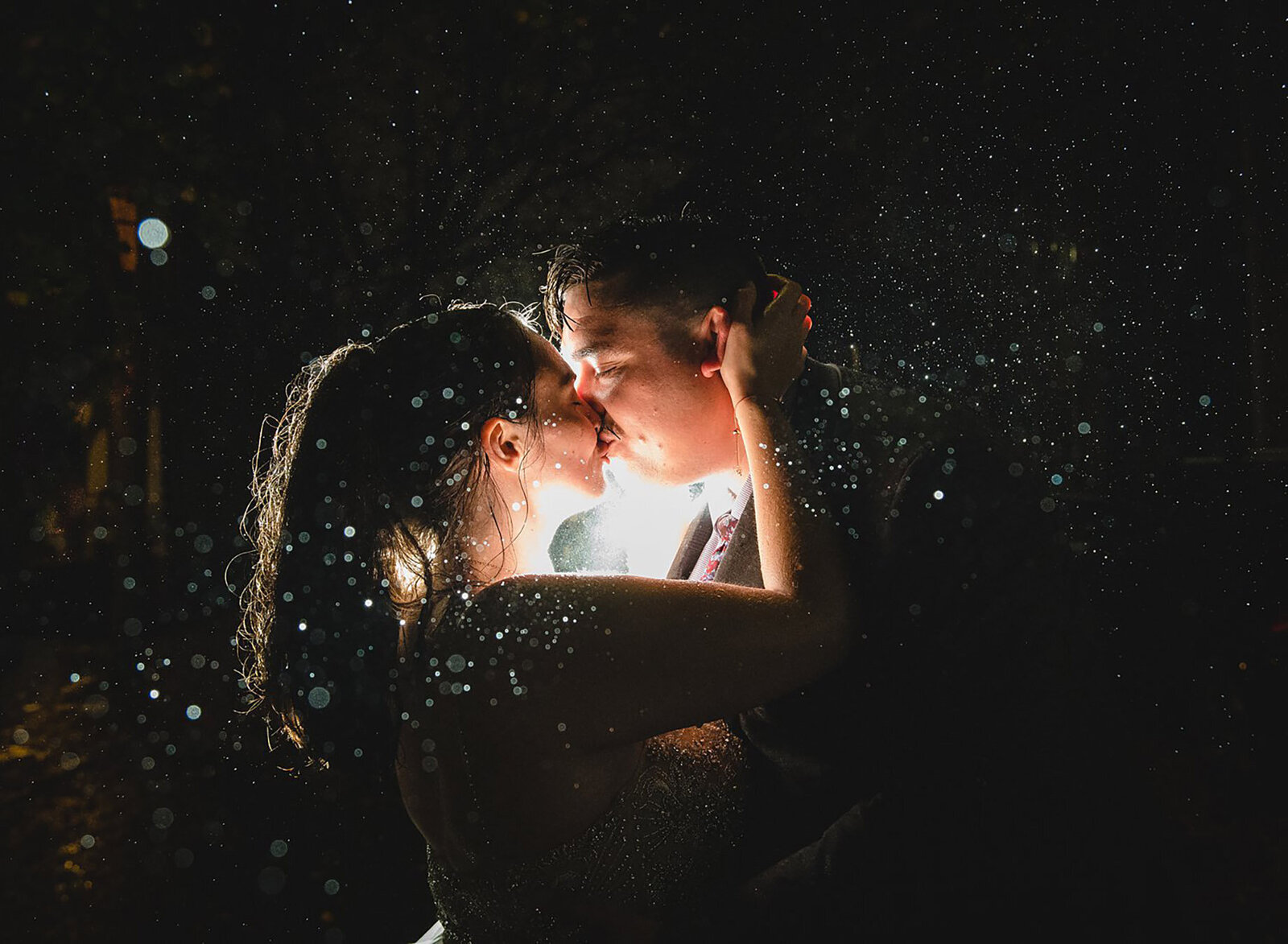 couple kissing in the rain at night for their elopement in New England