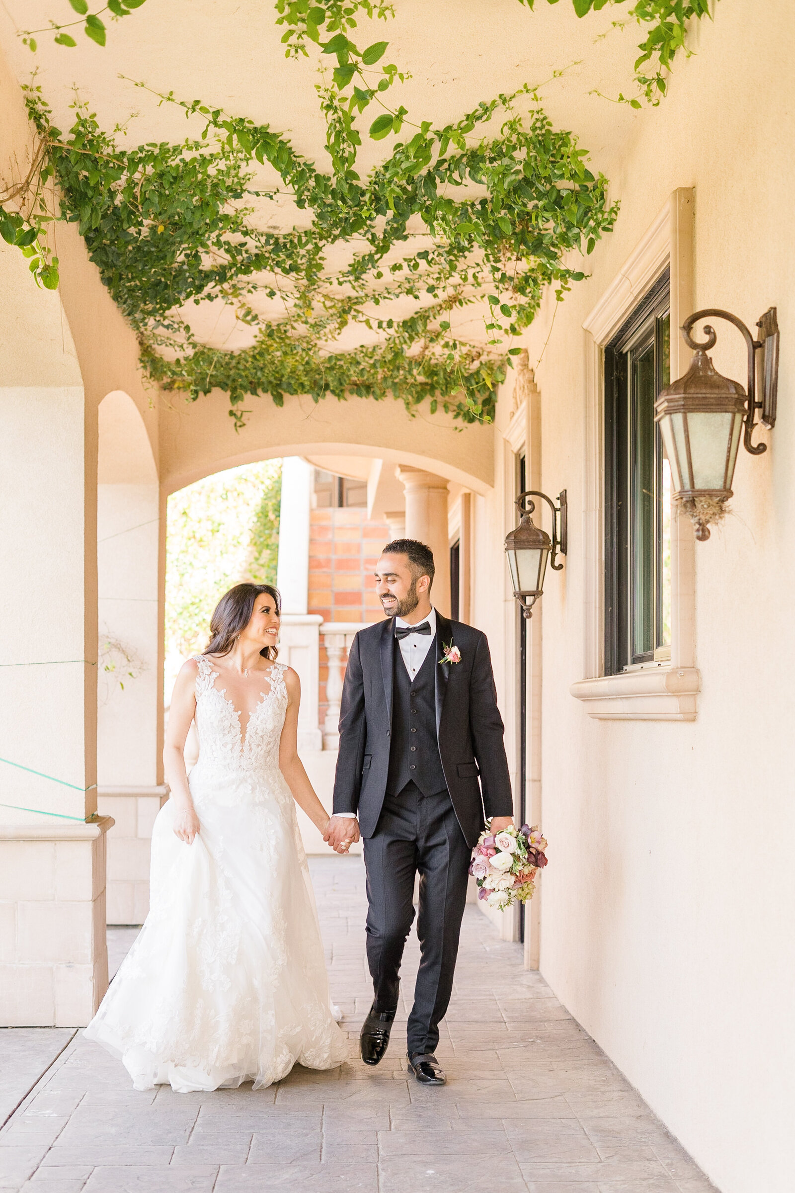 a  couple walks hand in hand at their Vista del lago estate wedding by adrienne and dani photography, napa wedding photographers