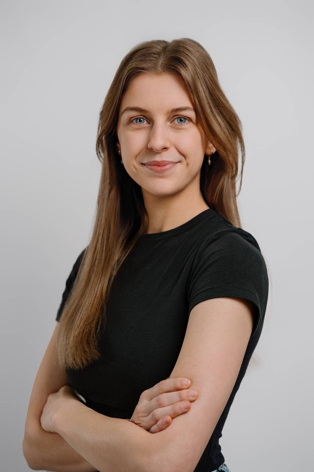 Professional portrait of a female taken in a studio, conveying her strength and professionalism. white backrop smirk