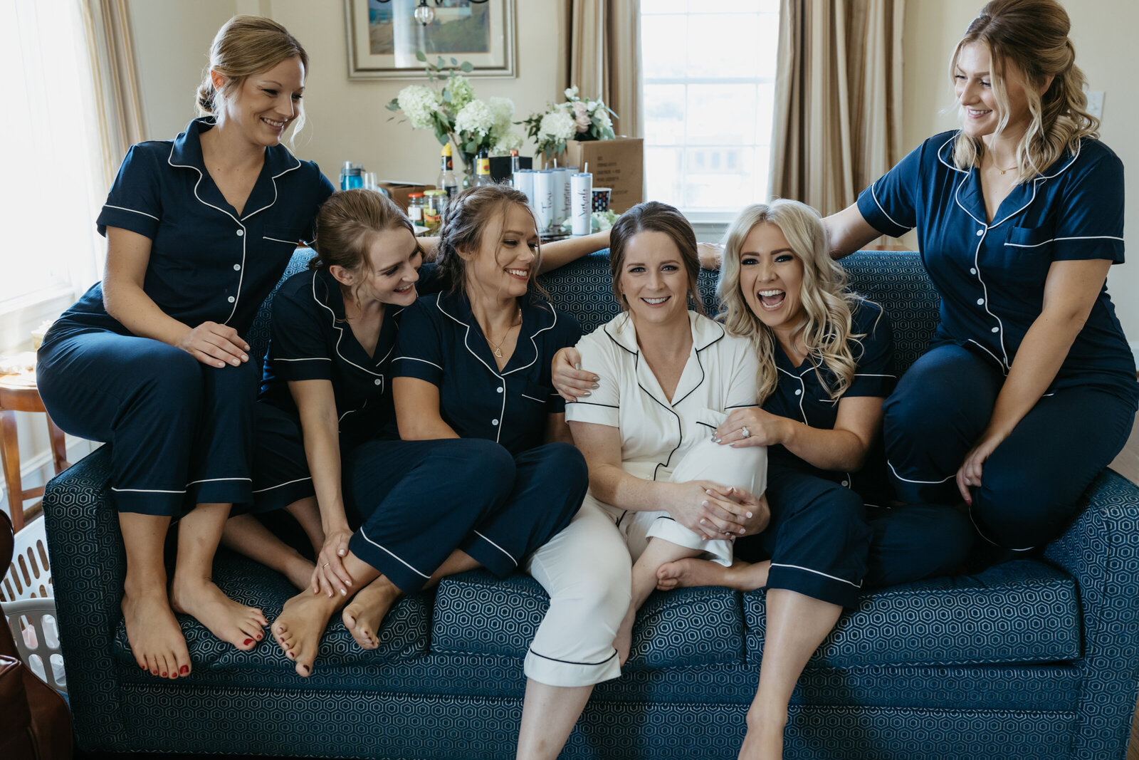 A bride and her bridesmaids sit together in matching pajamas