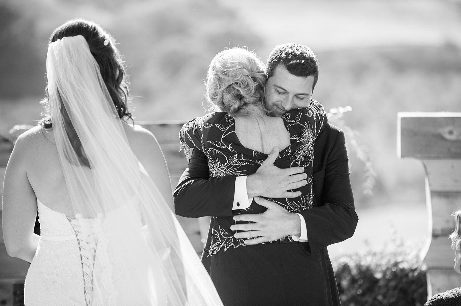 groom hugging mom at the end of the aisle