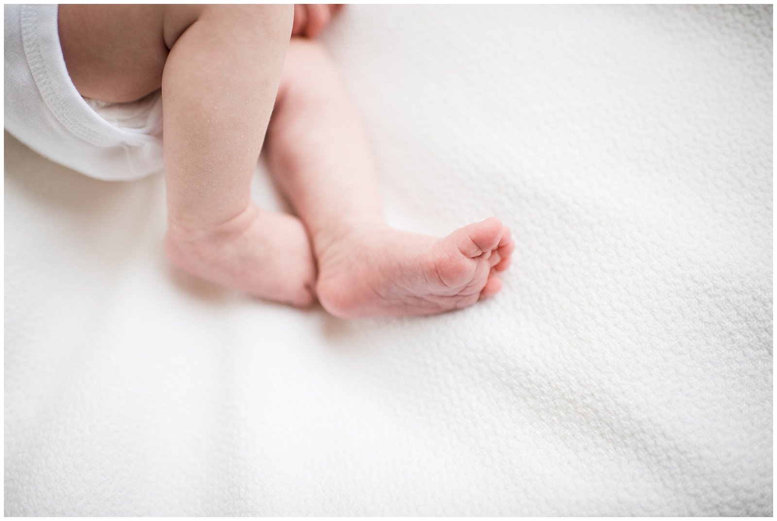 close up of baby feet on white sheet in home lifestyle newborn photoshoot Emily Ann Photography Seattle Photographer