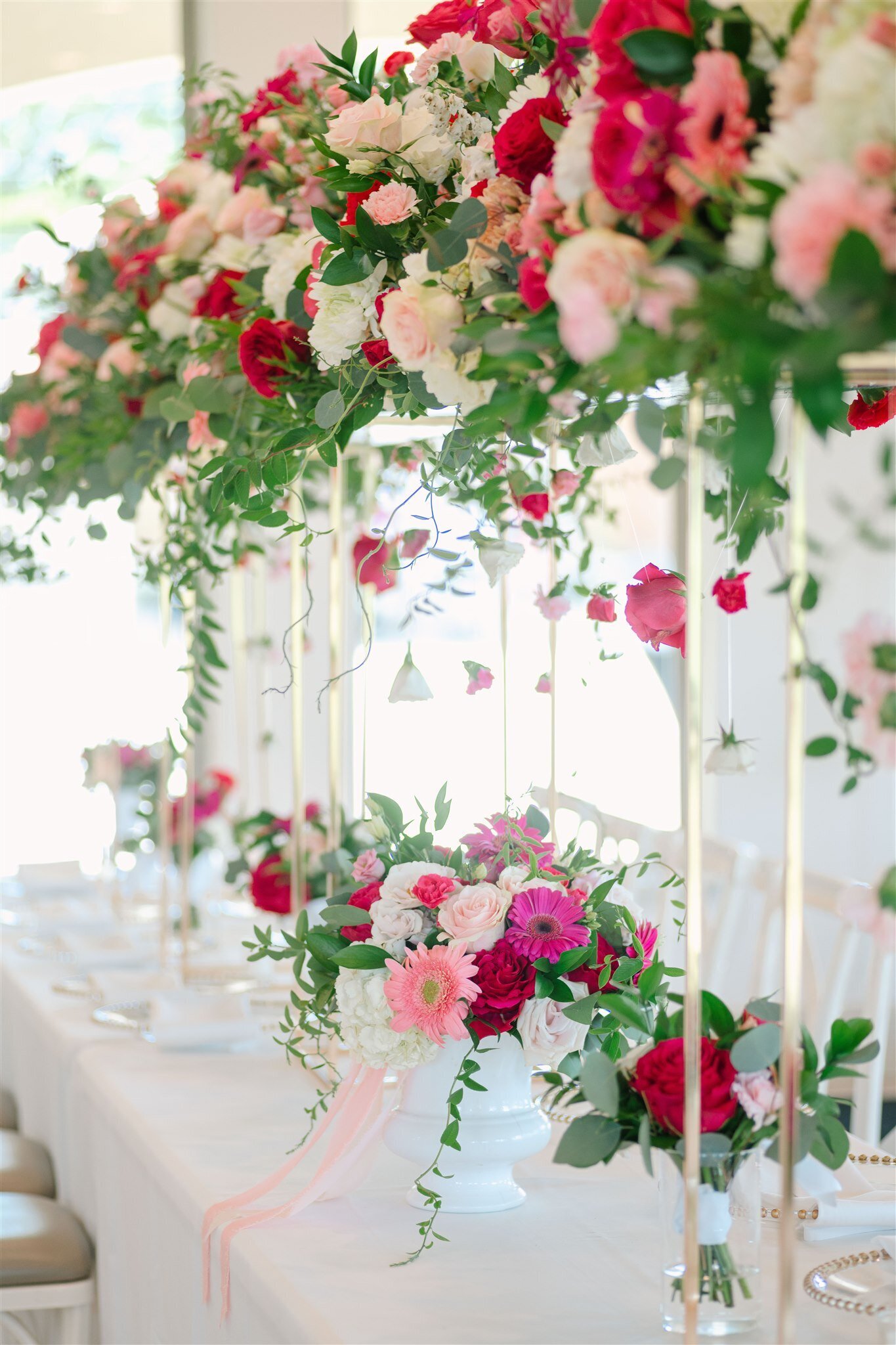 elevated long floral arrangement with hot pink gerbera  daisies and flowers hanging from the top