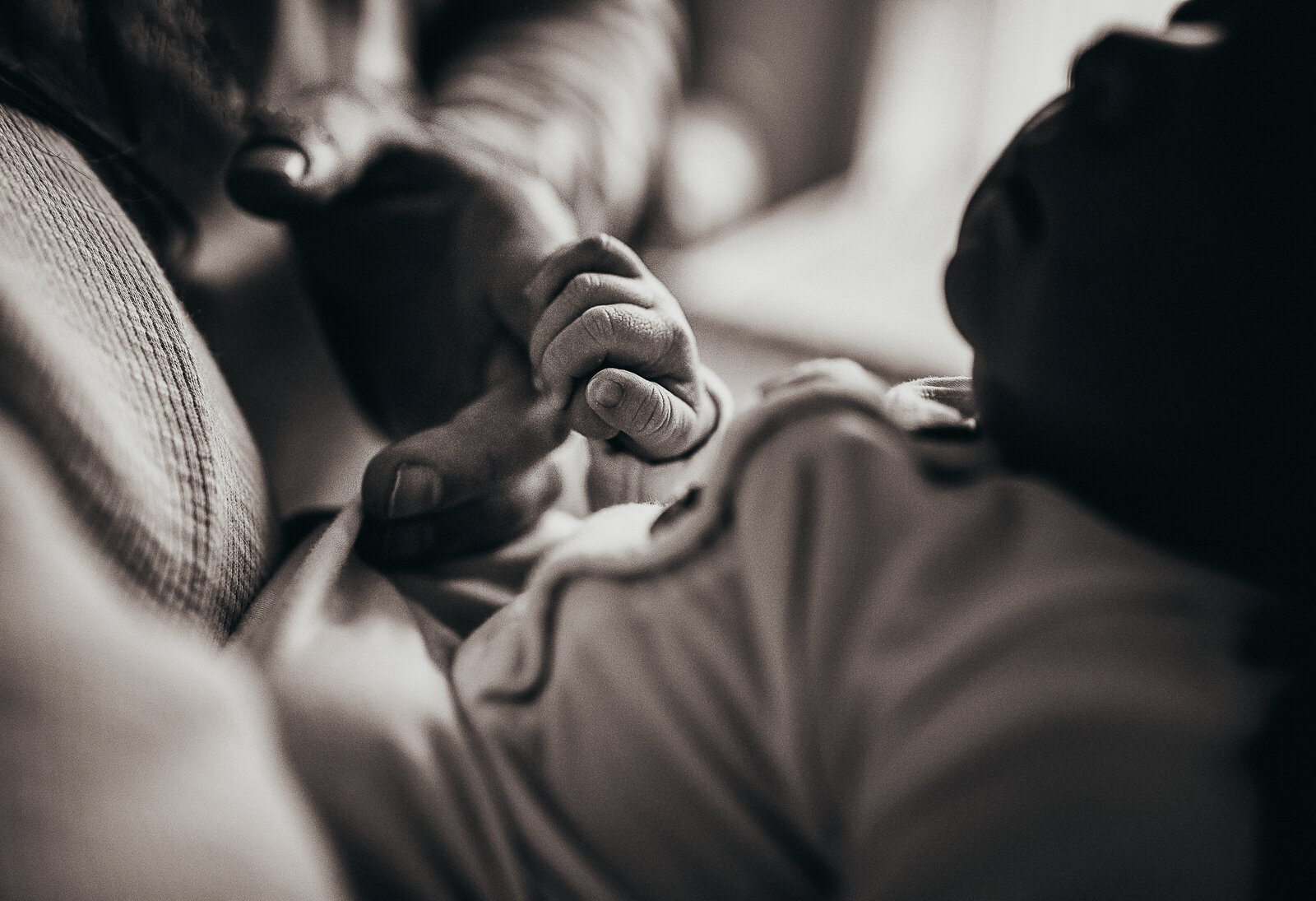 baby holding dad's finger