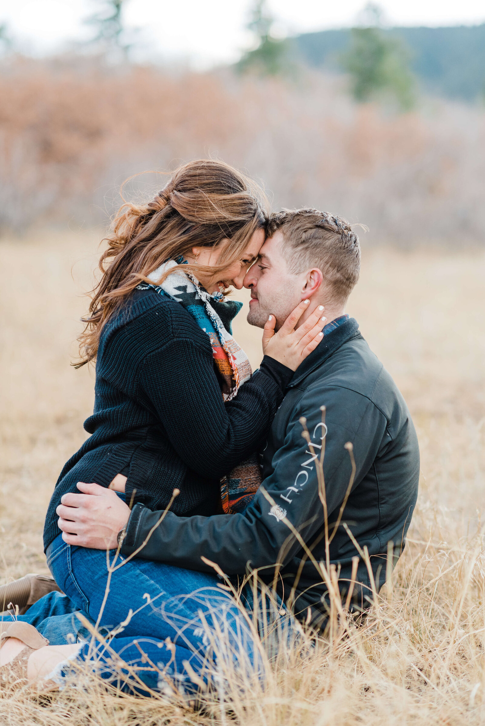 Man snuggling his fiance in a field