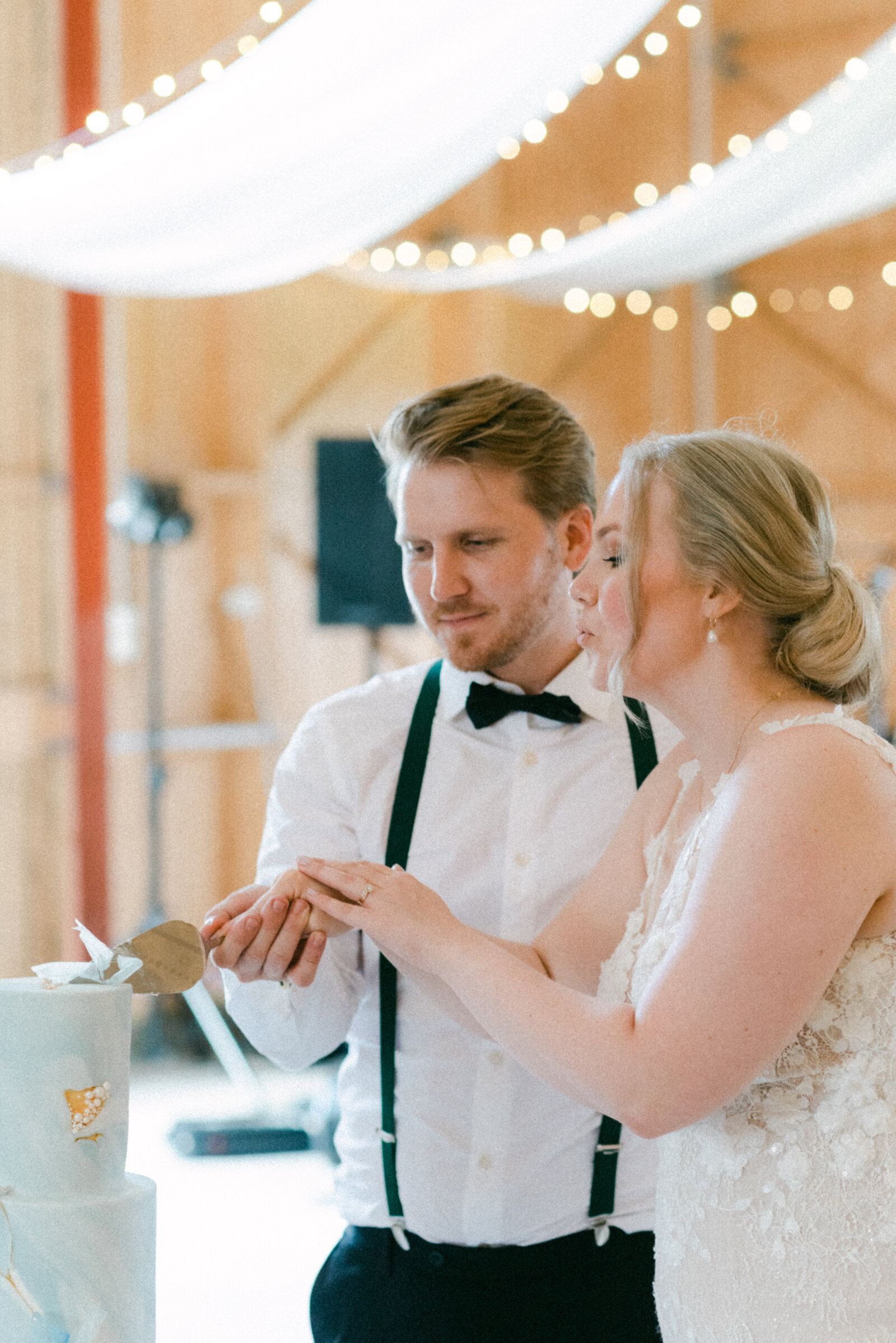 The wedding couple cutting the wedding cake in an image photographed by wedding photographer Hannika Gabrielsson.