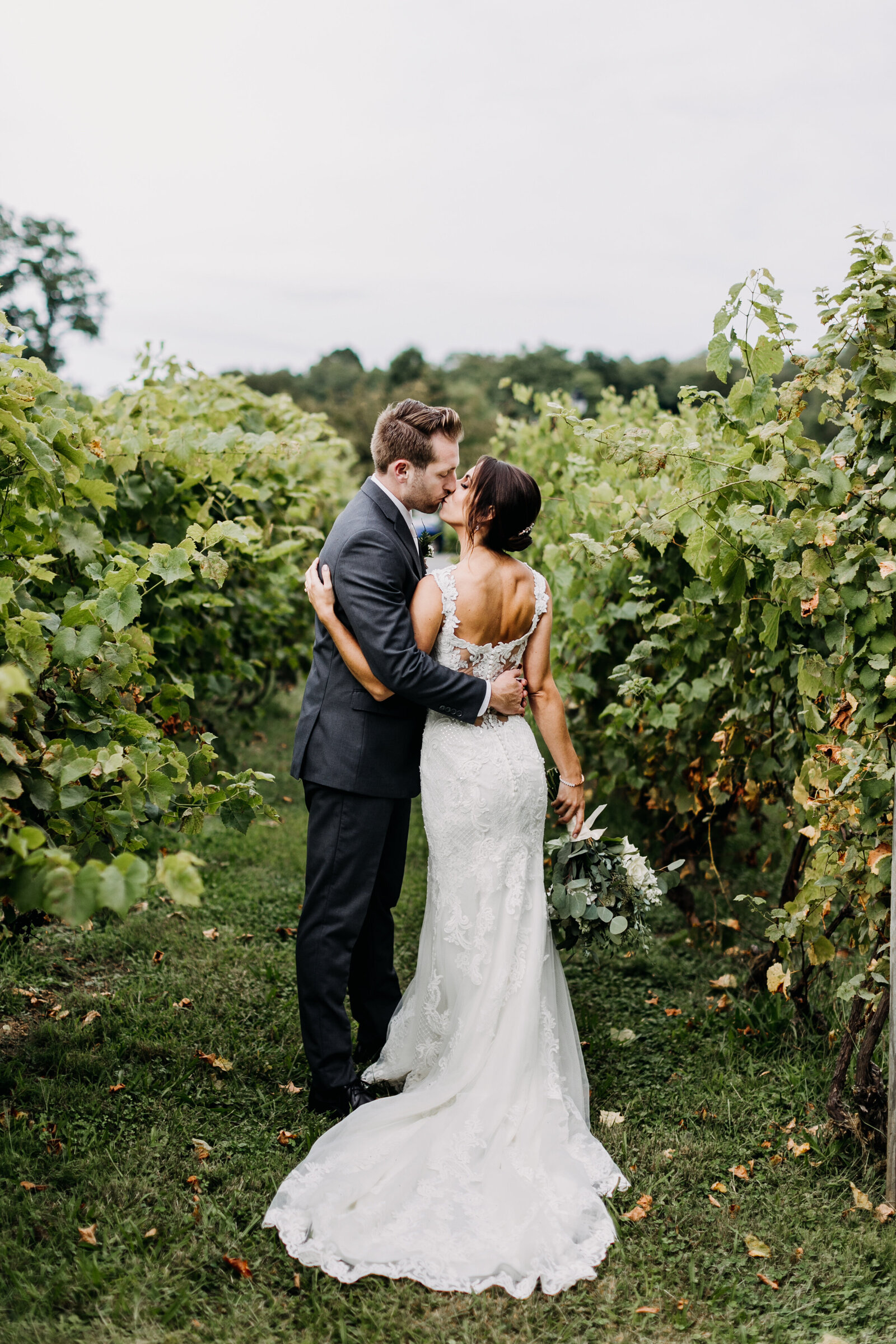 bride and groom kissing winery