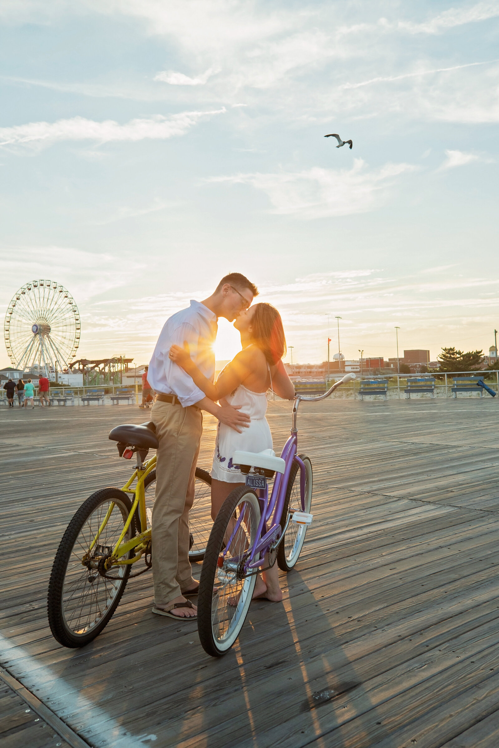 engaged couple biking on boardwalk in Ocean city nj