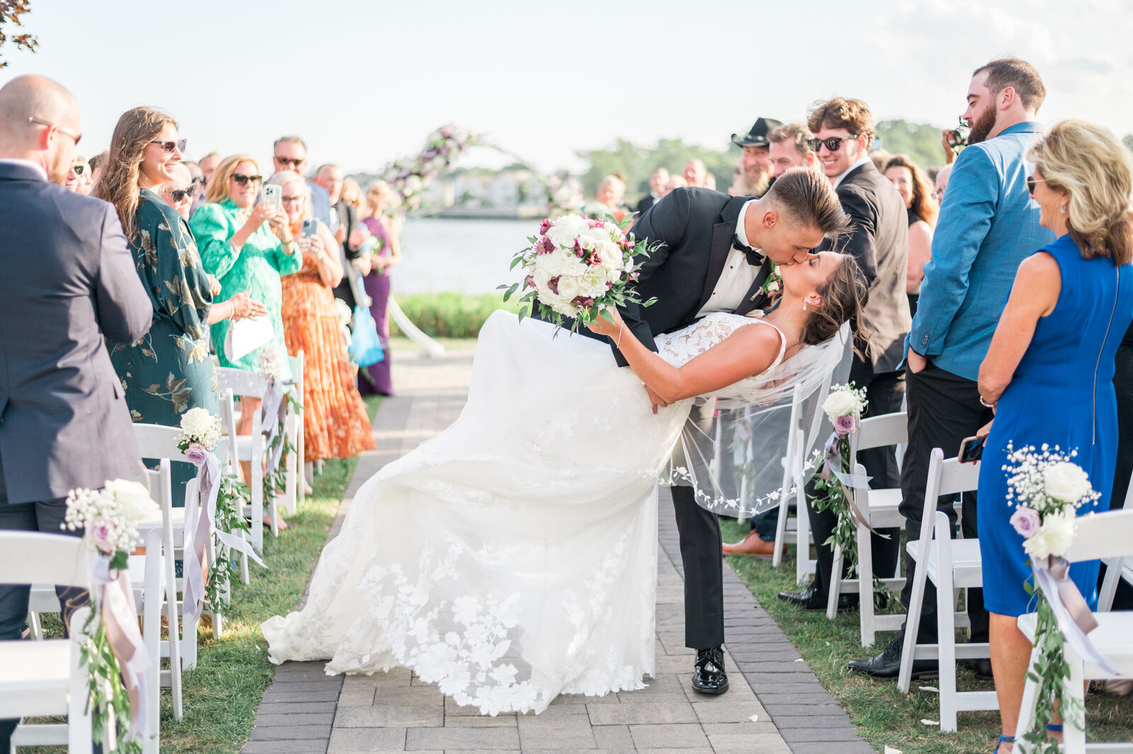 Mark dips bride, Noelle Lambert from Survivor for a kiss down the aisle during their outdoor New England wedding — photography by Sarah Surette Photography