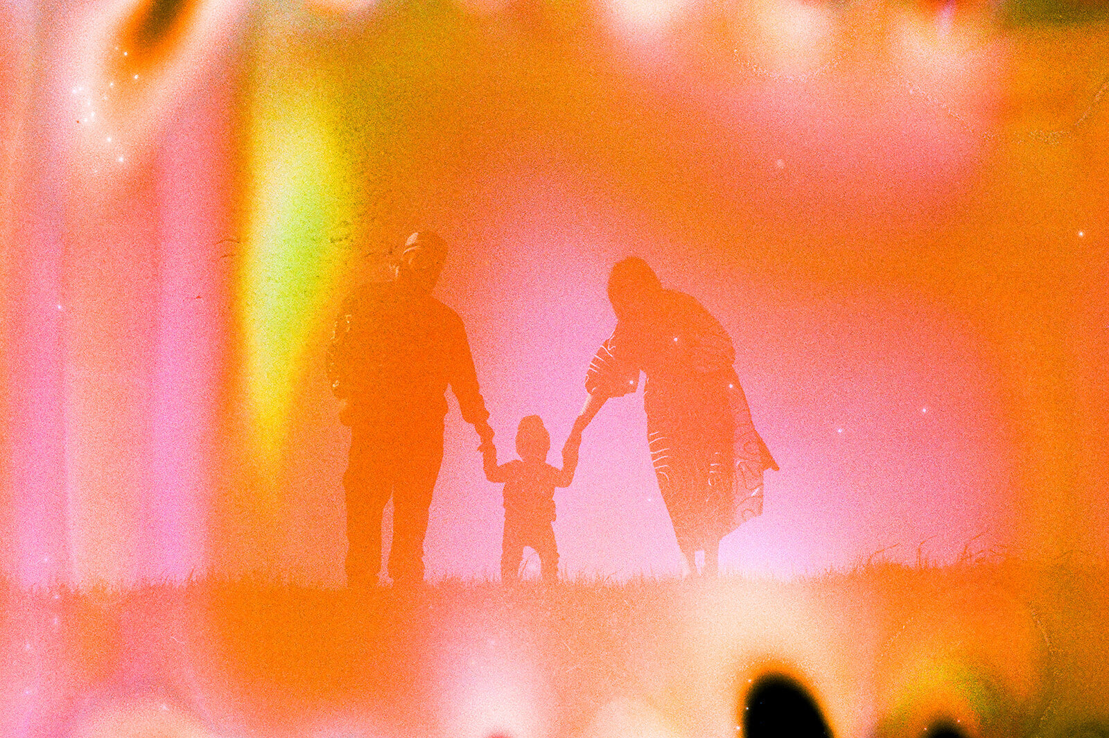 film soup photo of family of three standing on a grassy hill