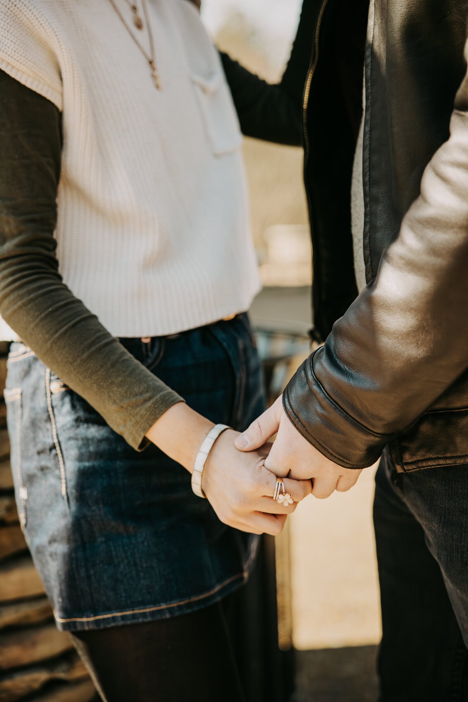 Close-up of a couple holding hands during their engagement session, capturing the intimate connection between them.