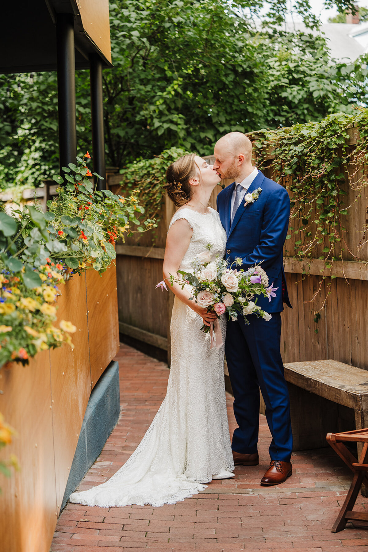 bridge and groom kiss in the courtyard of oleana in cambridge