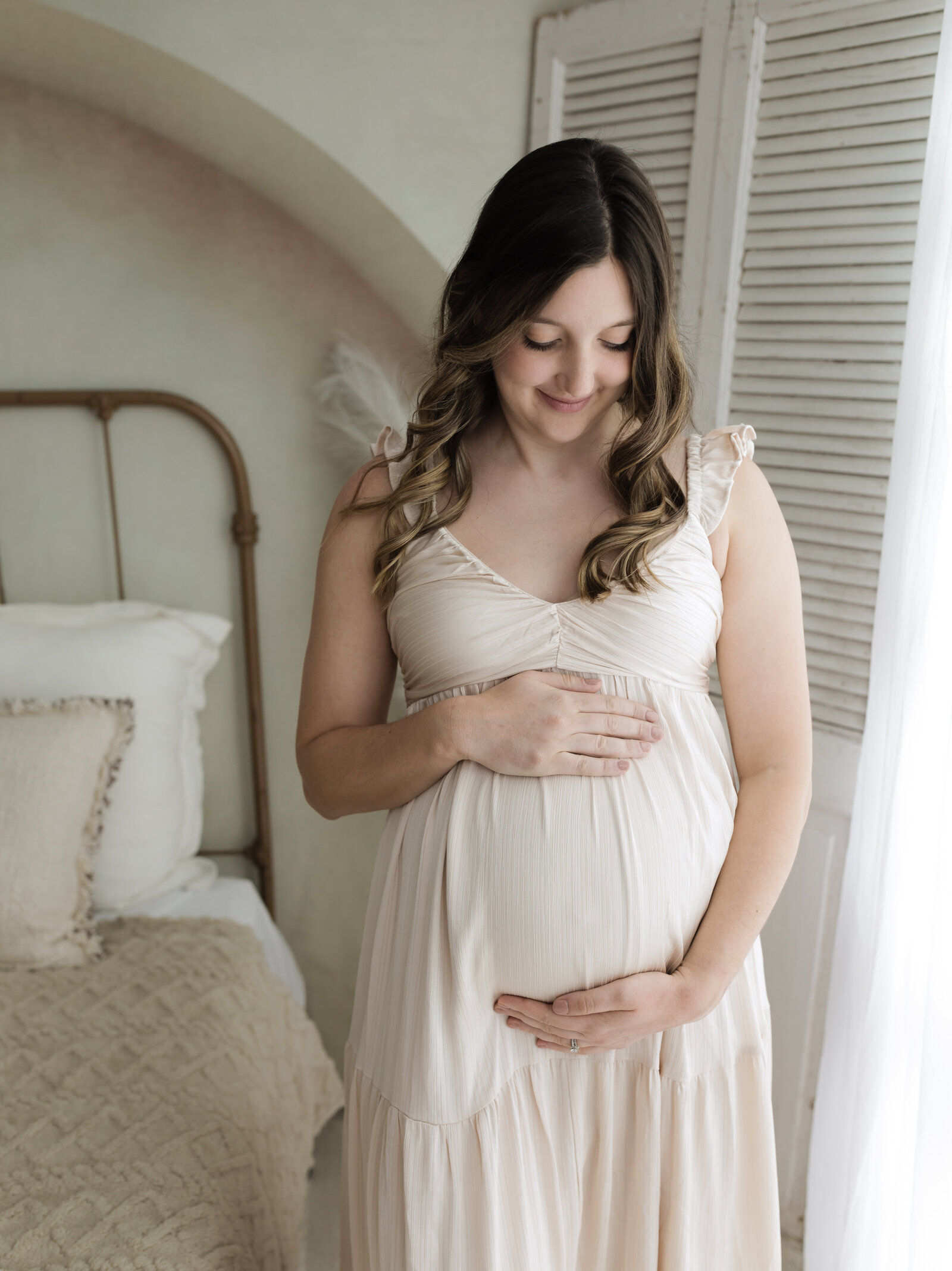 pregnant mother in cream maternity gown holding baby bump Cleveland maternity photographer