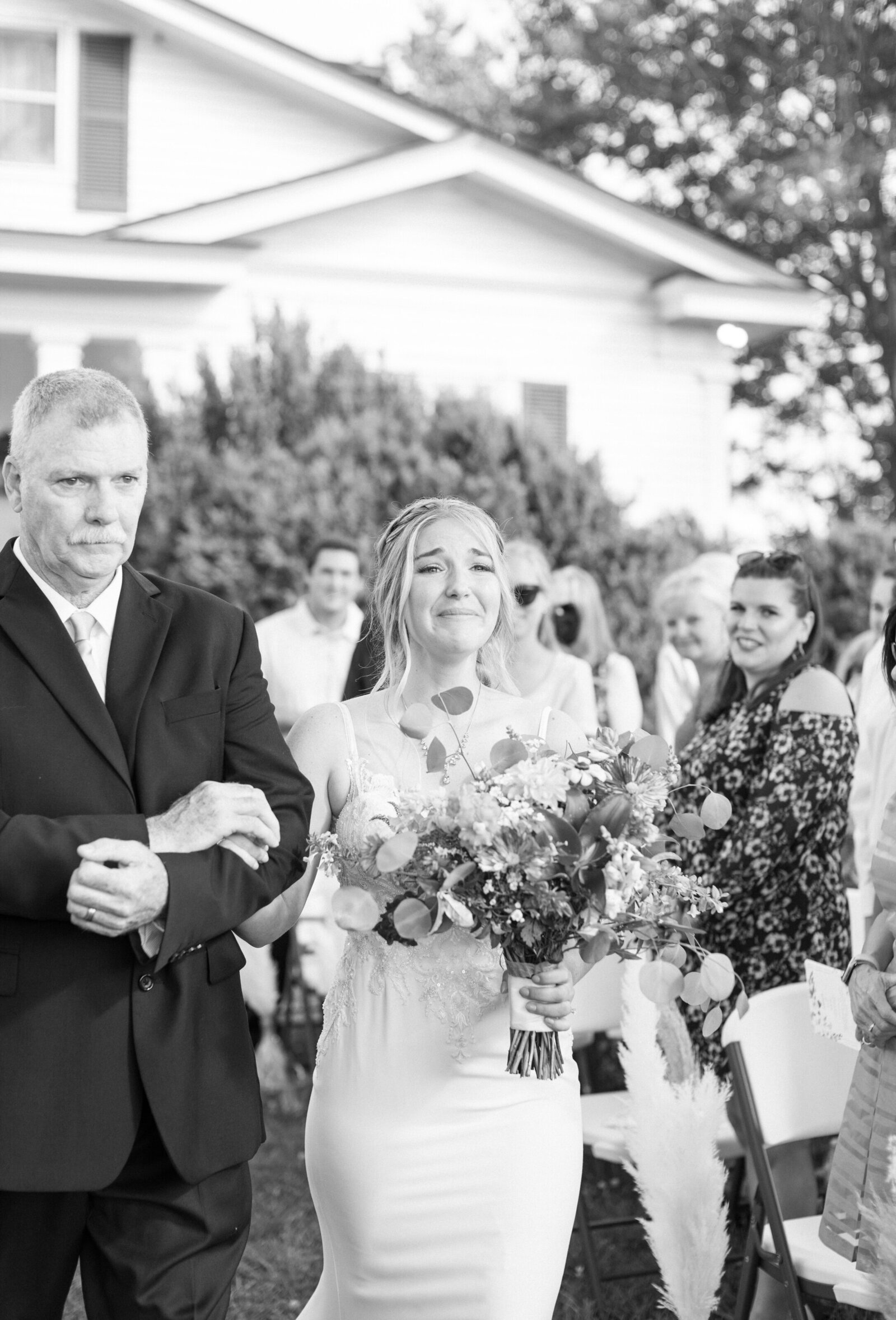 Bride cries while walking down the aisle