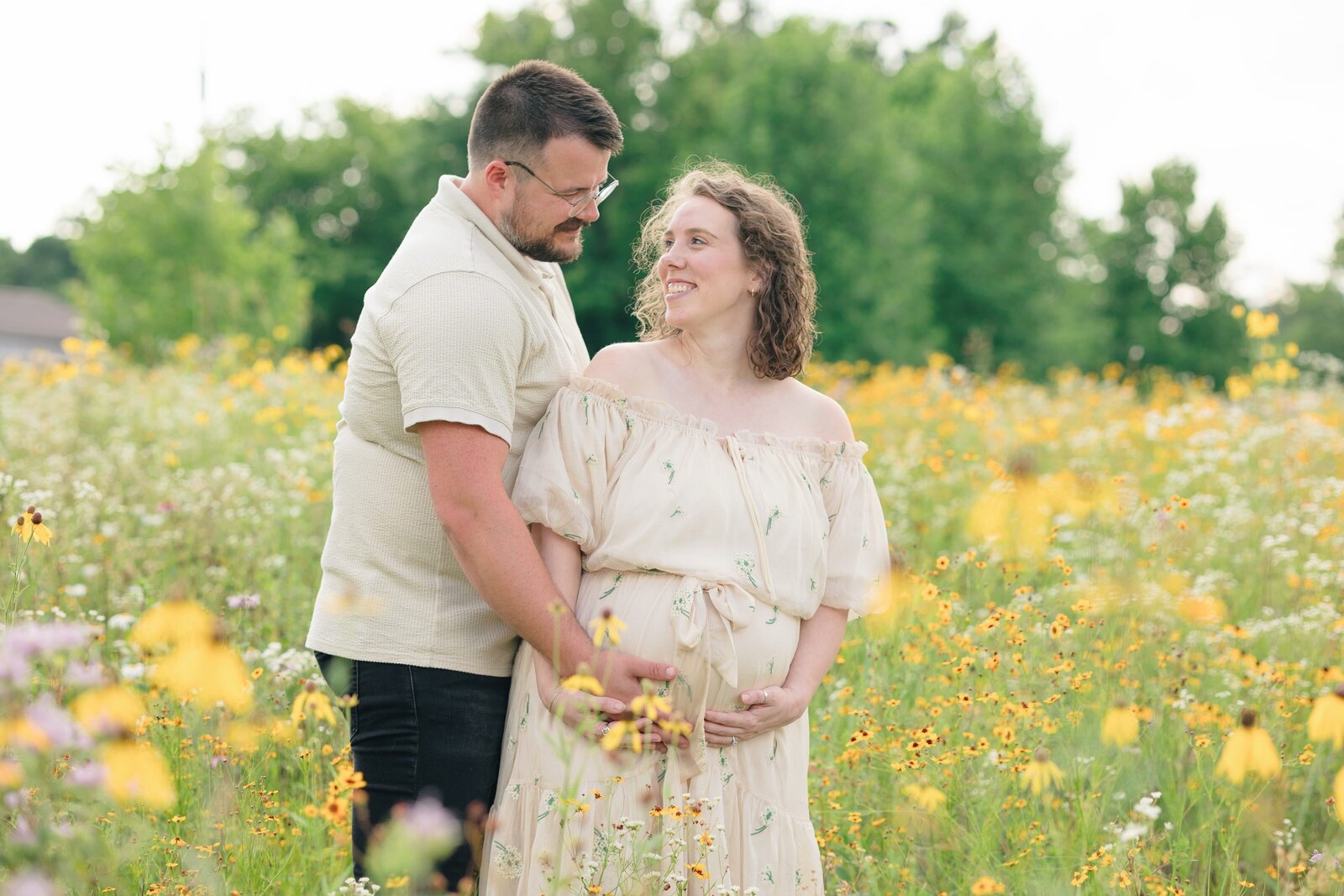 Portrait of an expecting couple in a field of wildflowers taken by louisville maternity photographer missy marshall