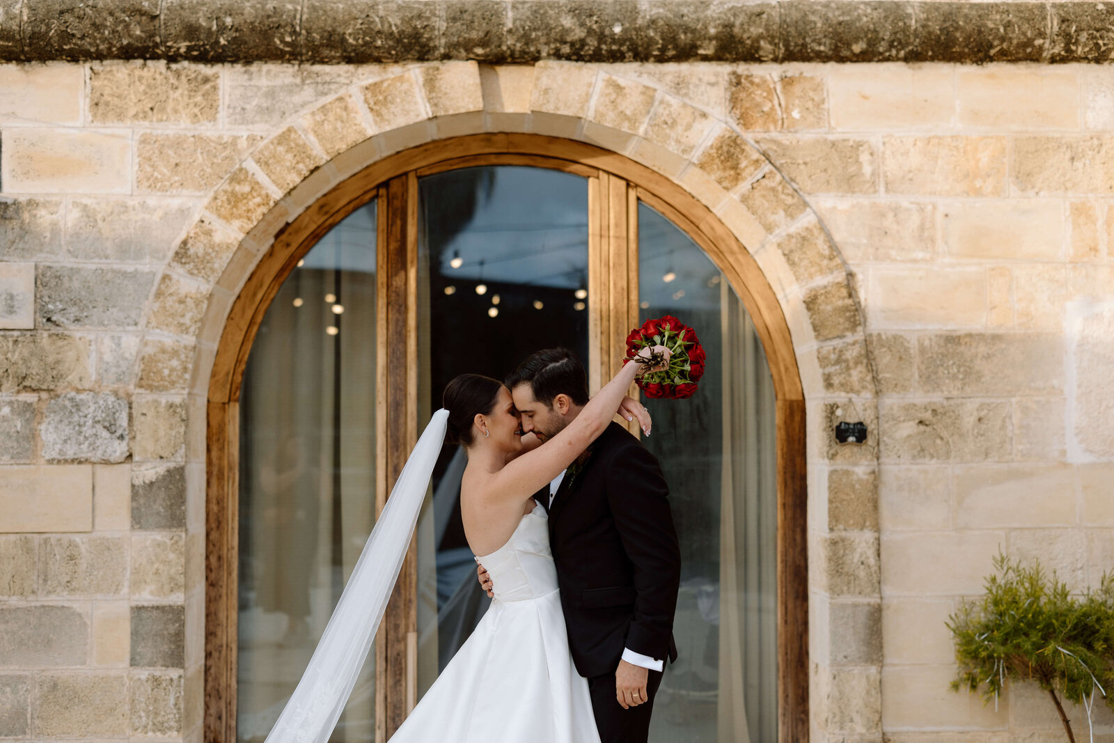 A couple kissing outside of their private villa in Puglia, Italy