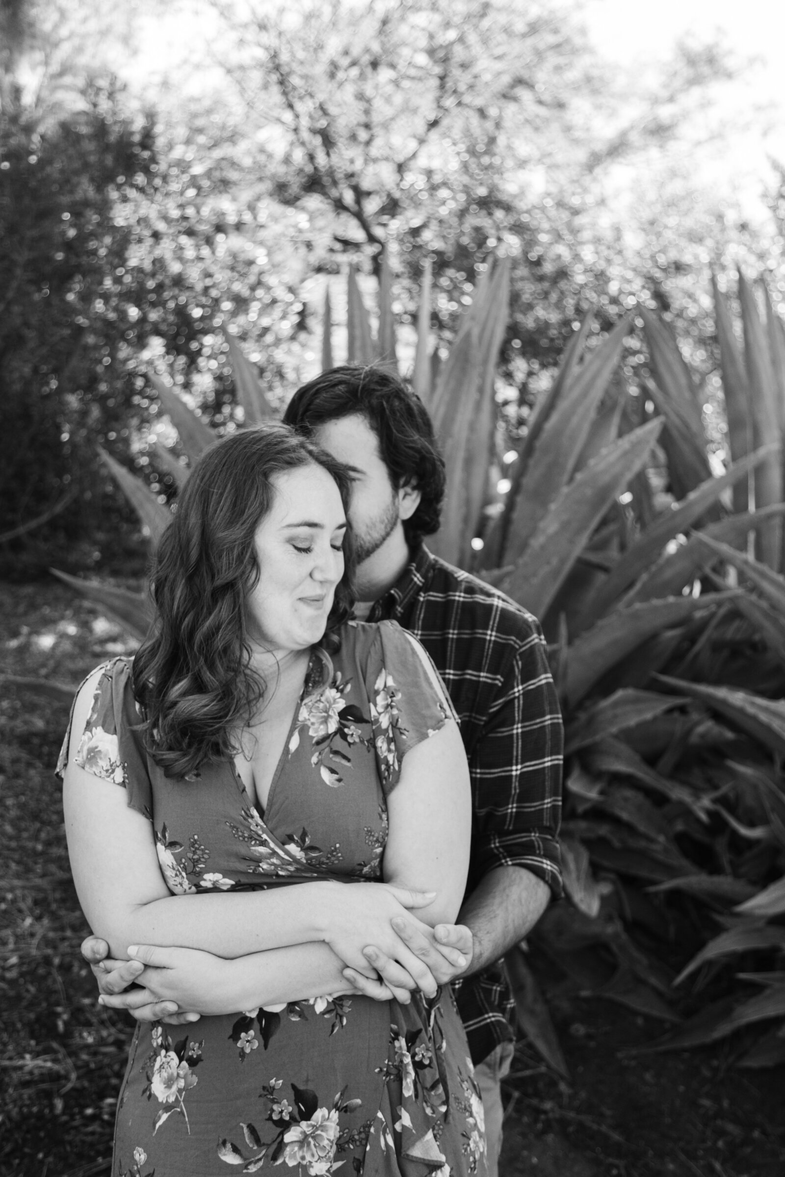 An engaged couple poses for photos in a garden in Los Angeles, Ca.