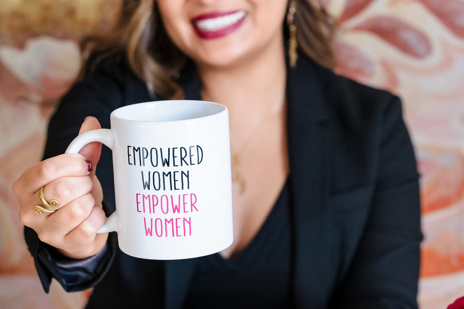 Life coach holds a mug with a quote "empowered women empower women"