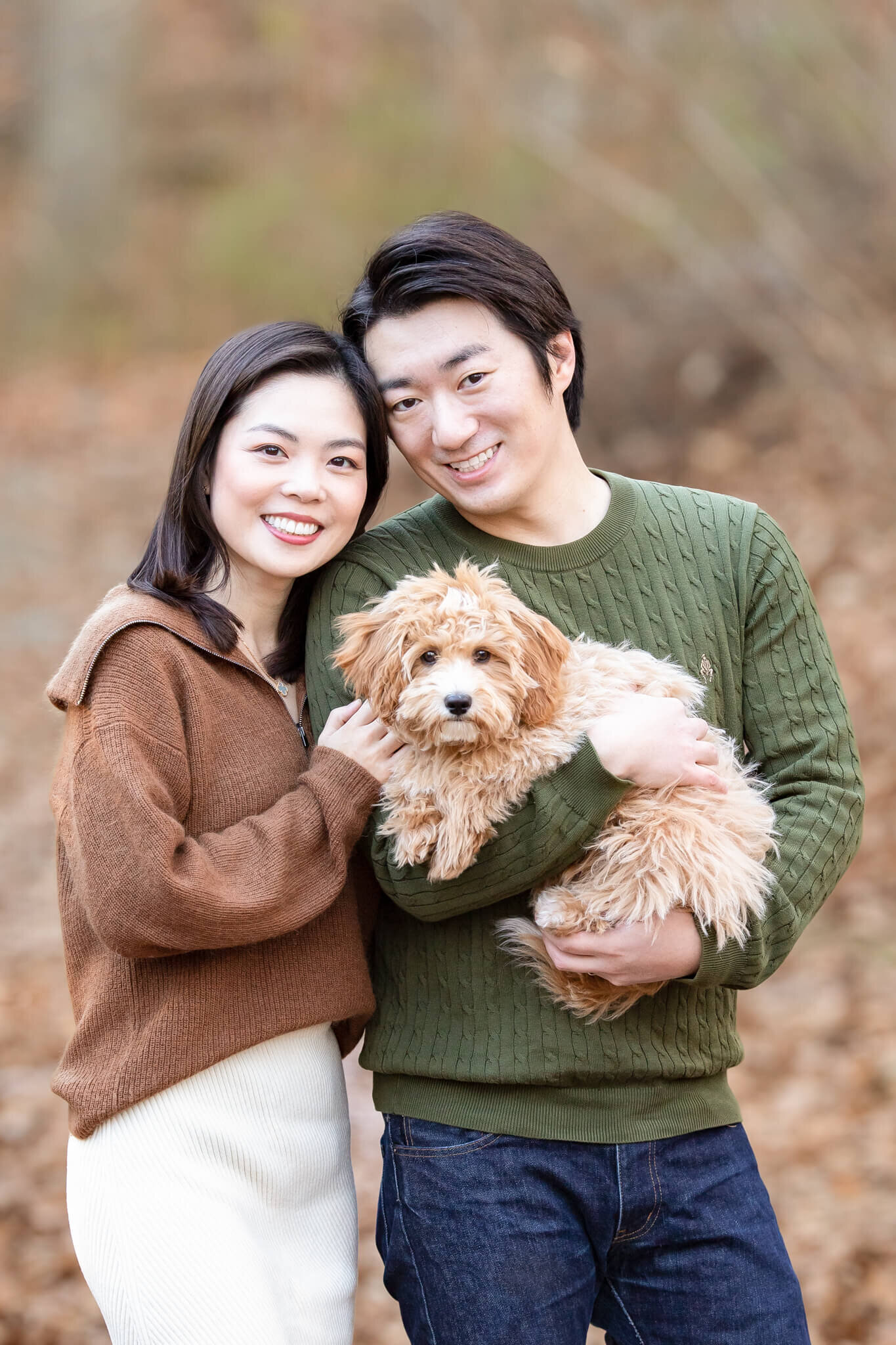 Couple standing together holding their puppy