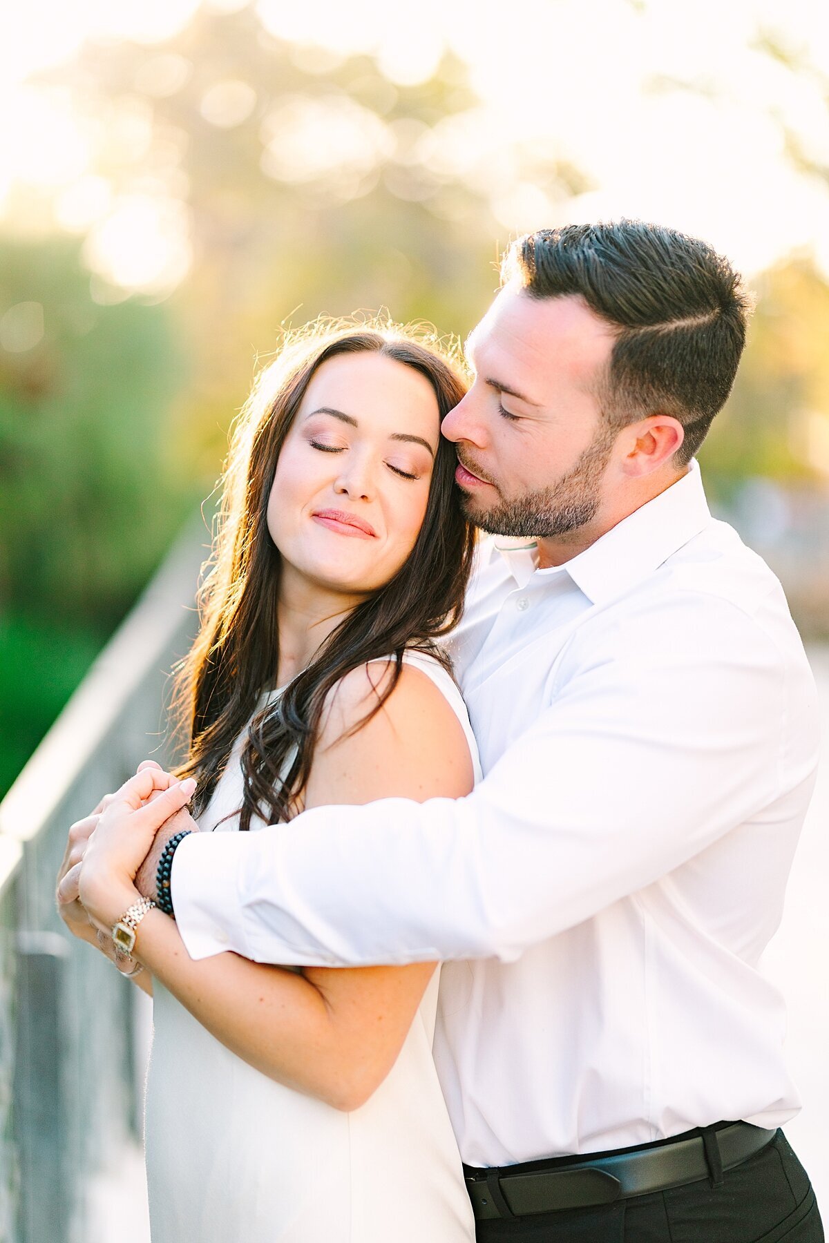 Groom kissing bride on the temple in front of the tower at Balboa Park taken by engagement photographer, Sherr Weddings.