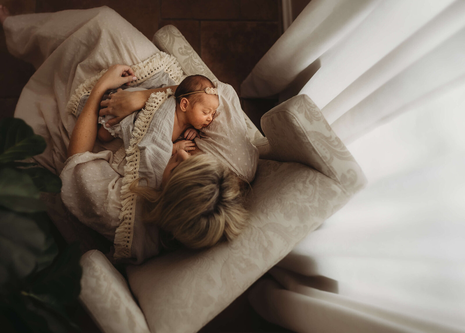 Mother gently rocking her newborn in a arm chair